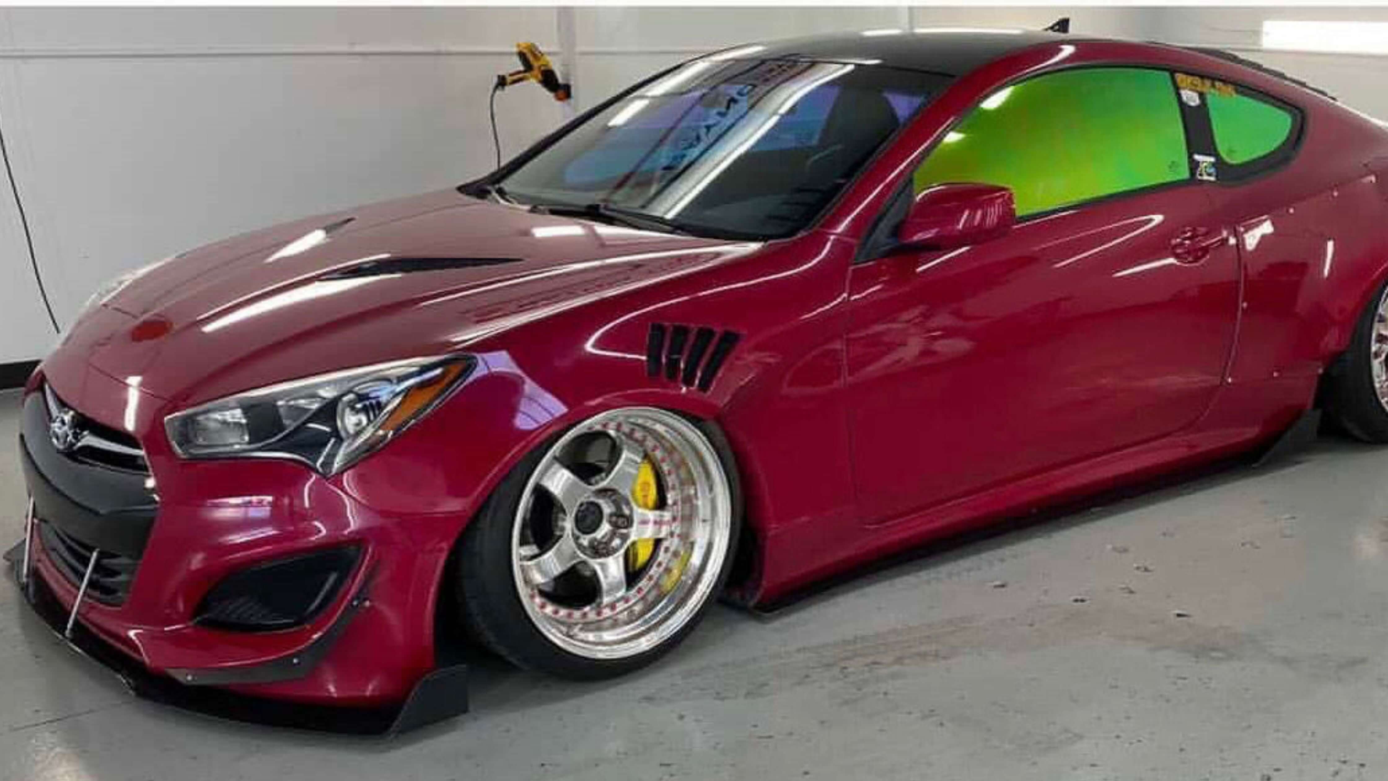 A sleek car with expertly tinted windows parked in a stylish garage setting.