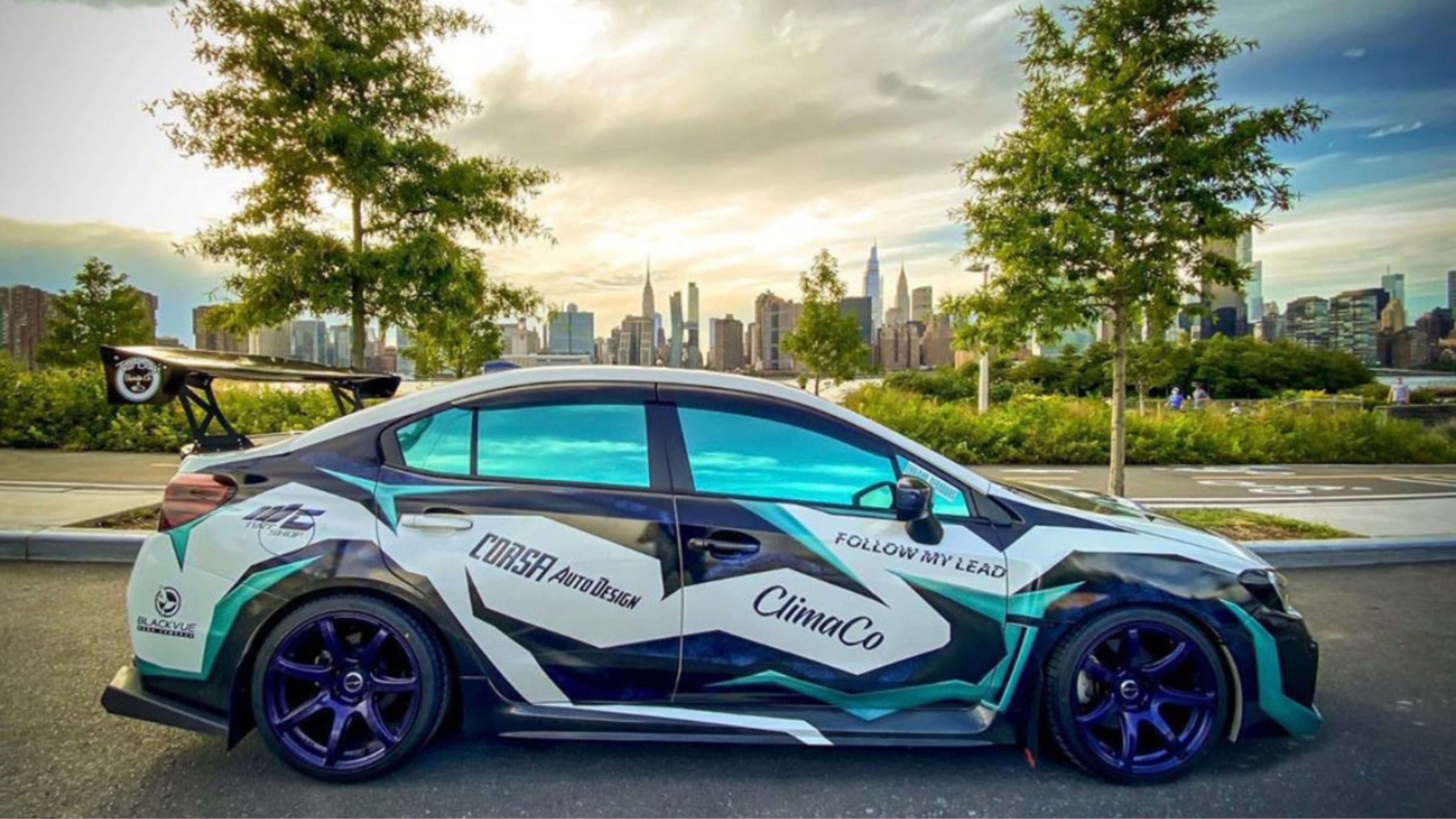 DIY car window tint removal on a stylish car with city skyline.