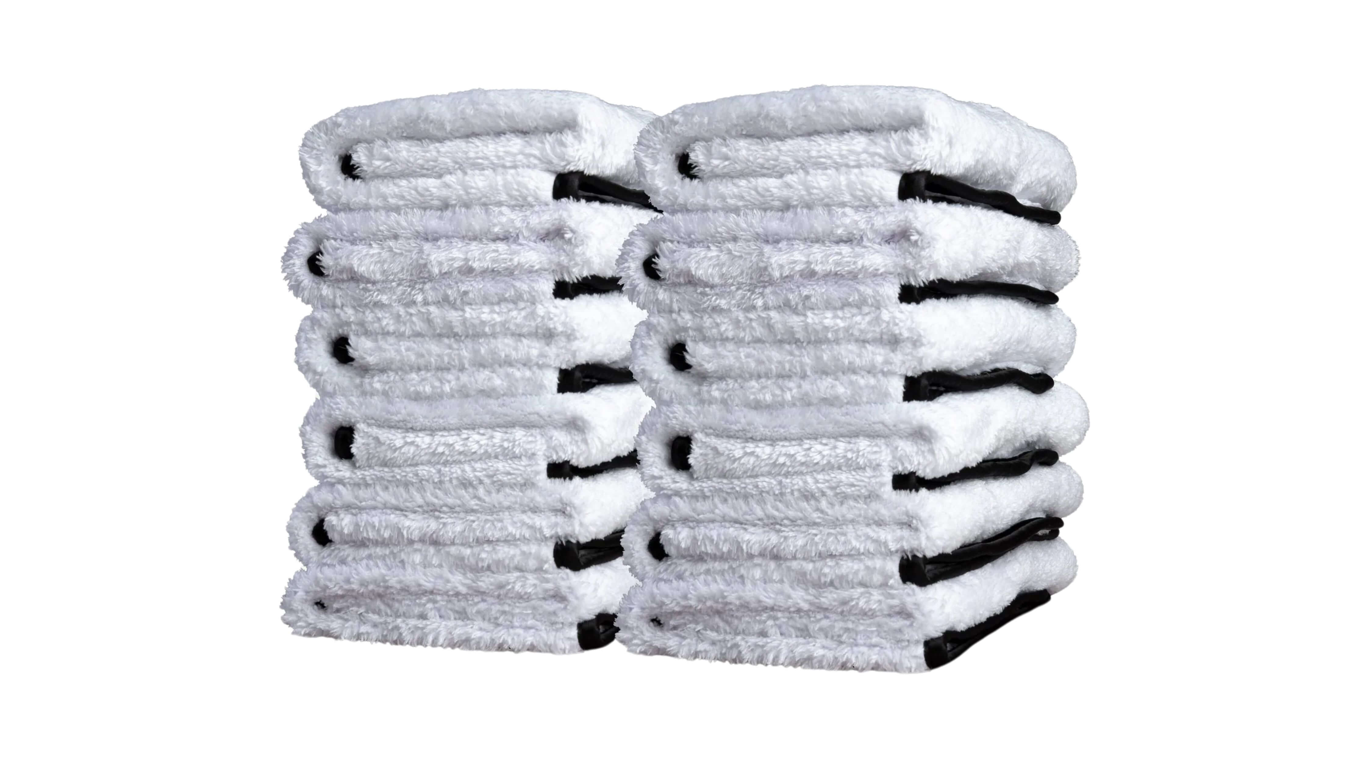 How do you clean a microfiber cloth? Two stacks of folded white towels with black edges.