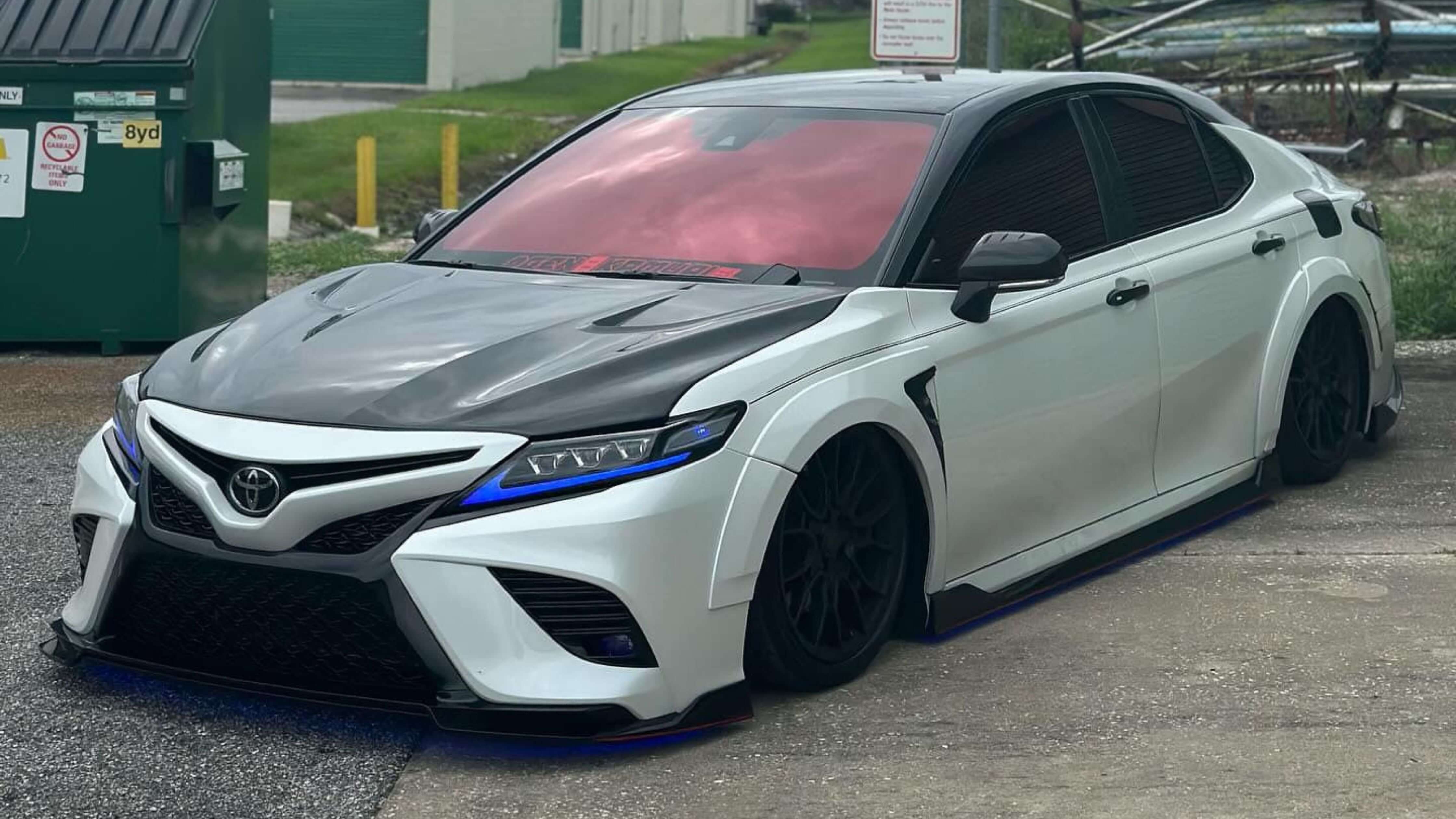 How much does it cost to tint windows on a car? A stylish white and black sedan with tinted windows, illustrating cost-effective tint options.