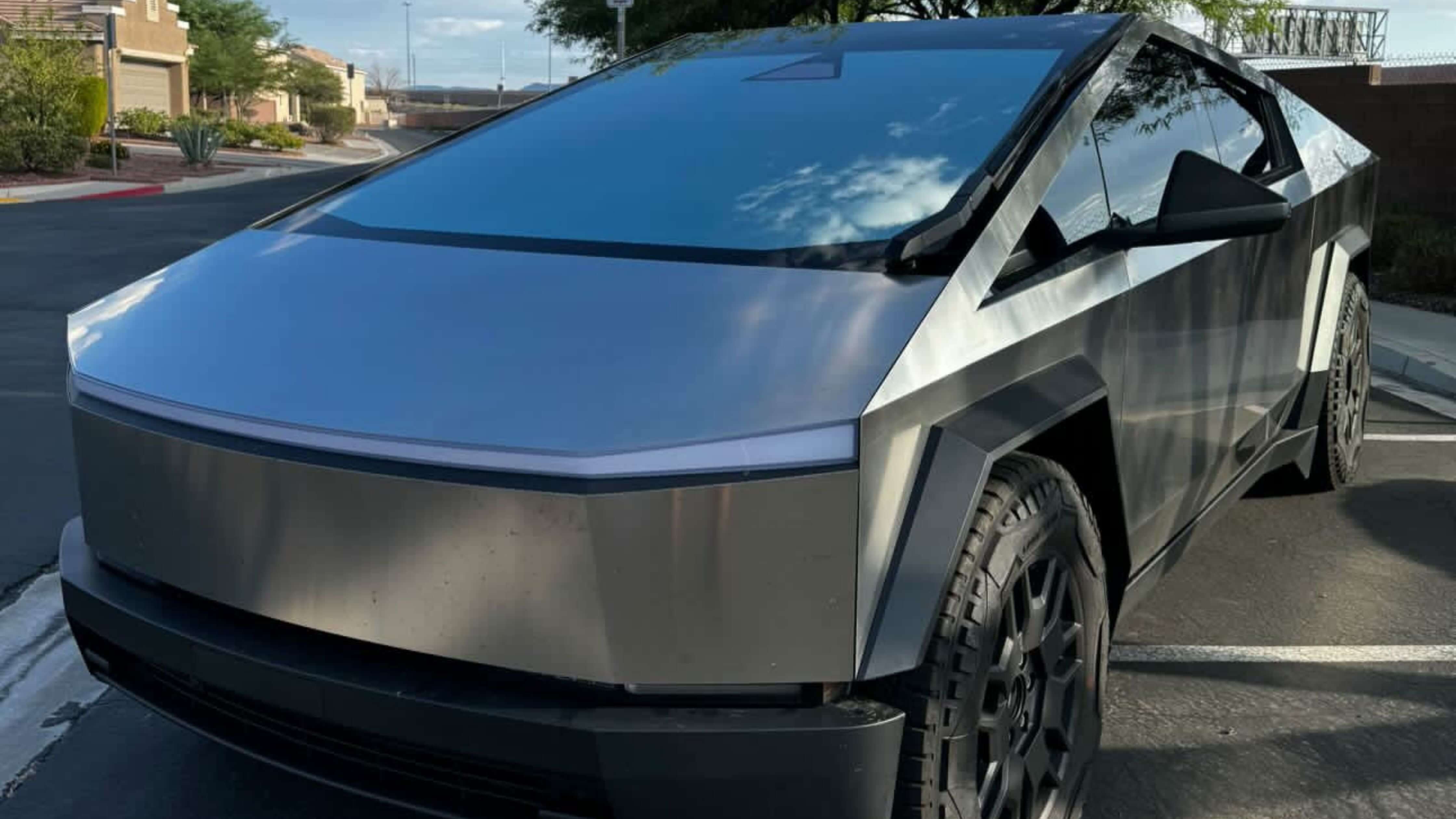 Close-up of car window with partially removed tint film, showcasing tint removal process.