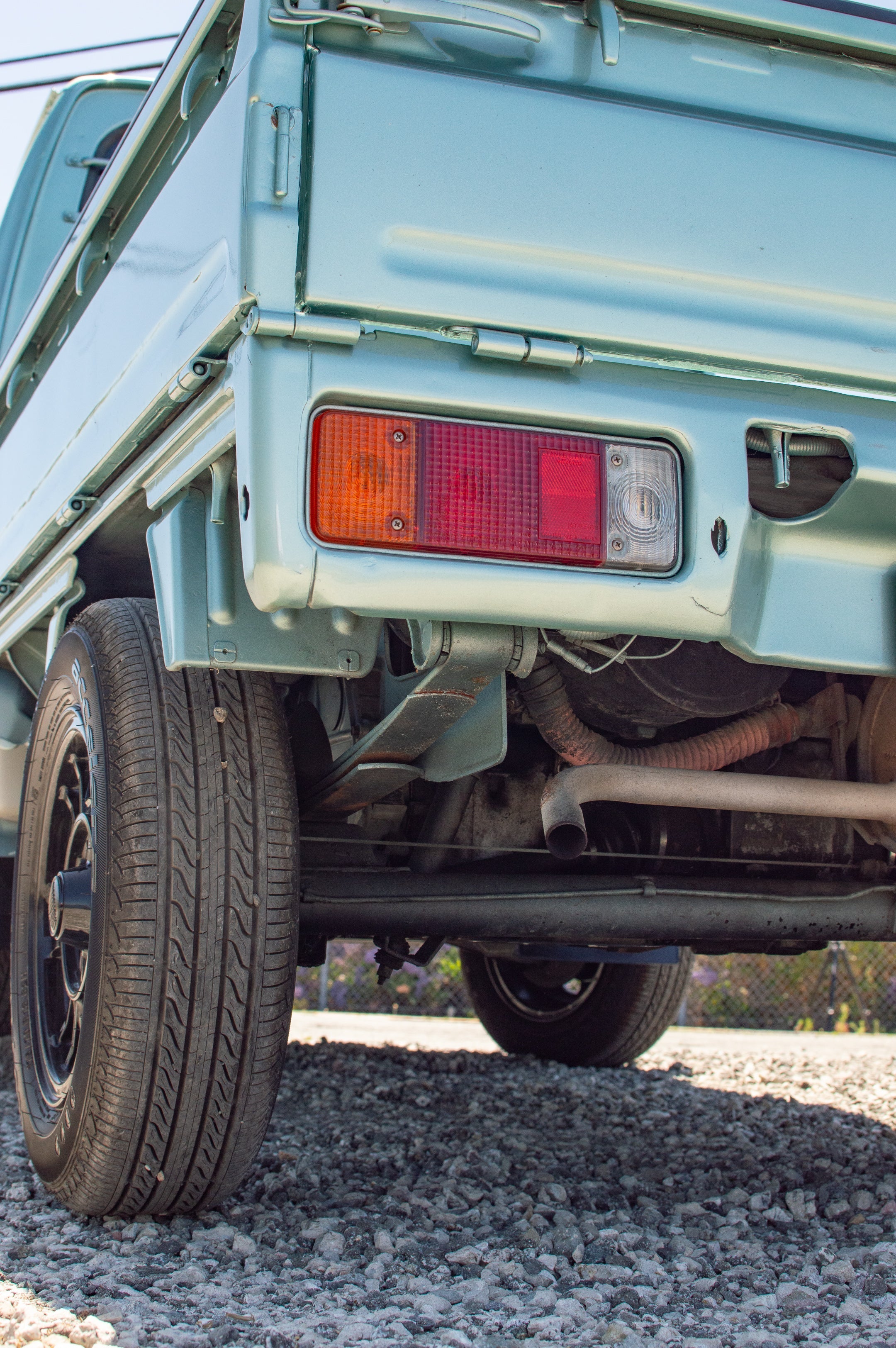 Suzuki Carry with lift kit driving on rough terrain, enhanced ground clearance.