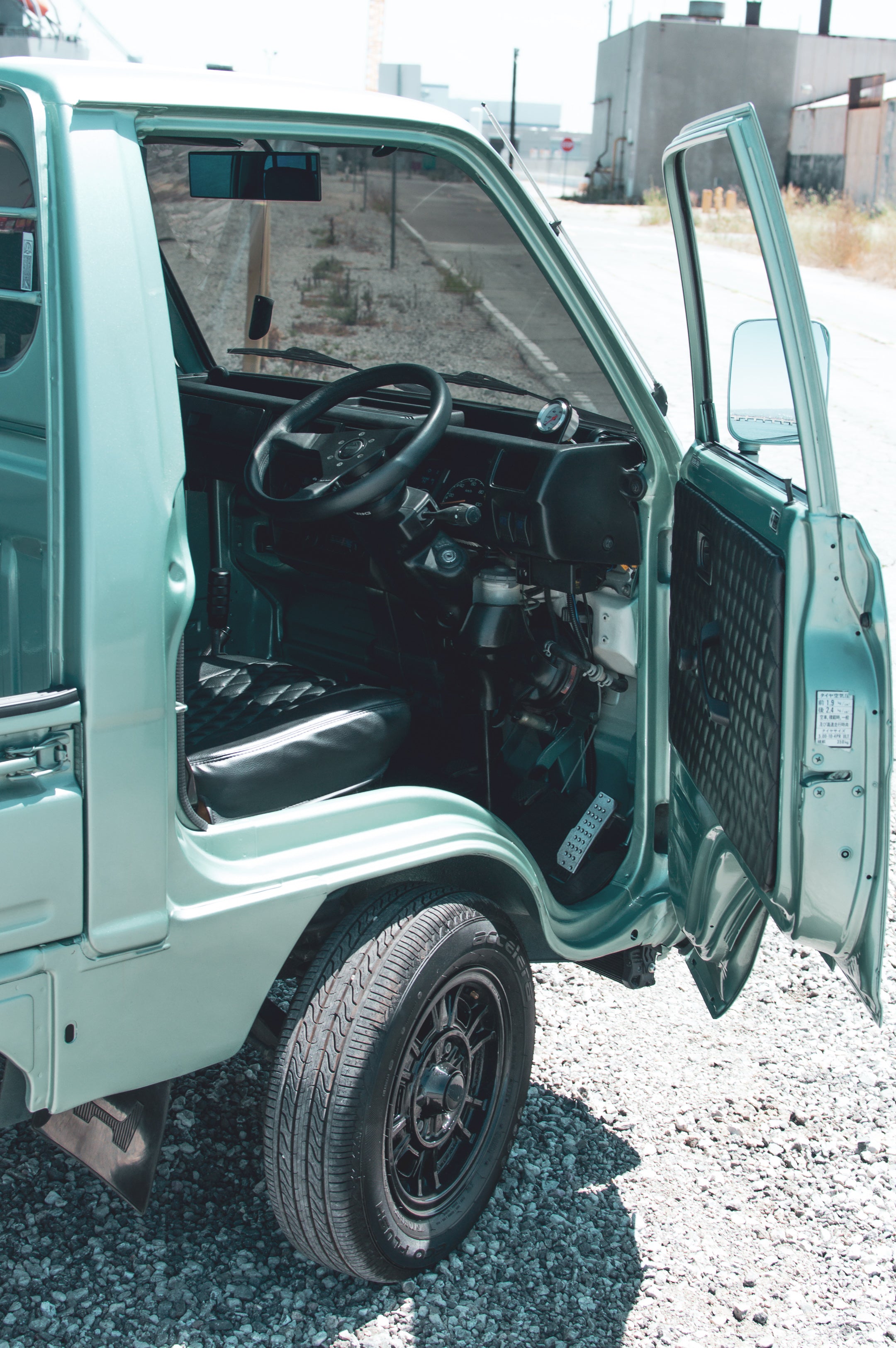 Image of a kei truck navigating city streets, illustrating its compact design and street legal features.