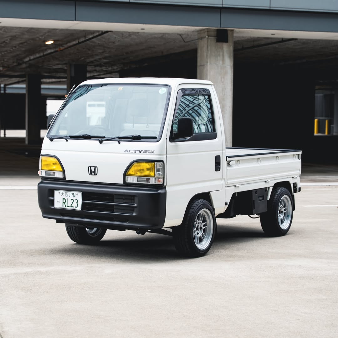 Clean white Honda Acty 4WD SDX kei truck featuring aftermarket wheels, highlighting its practical trim level ideal for daily tasks.