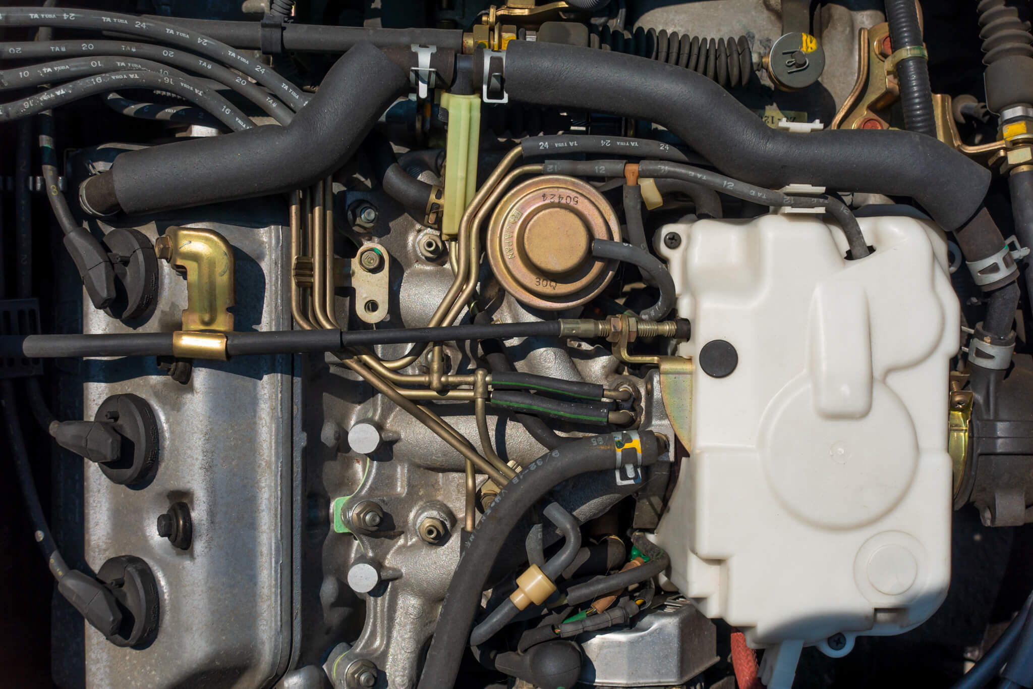 Detailed view of Honda Acty Van engine components for HH3, HH4 models from 1990-1999, showcasing OEM-quality exhaust manifold, water pump, and valve system available at Oiwa Garage.