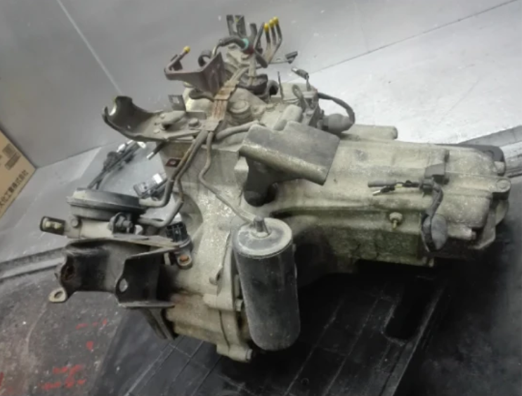Honda Acty Transmission for HH5 and HH6 models (1999-2009), featuring robust design with visible mounting points and gears, ideal for maintaining vehicle performance.