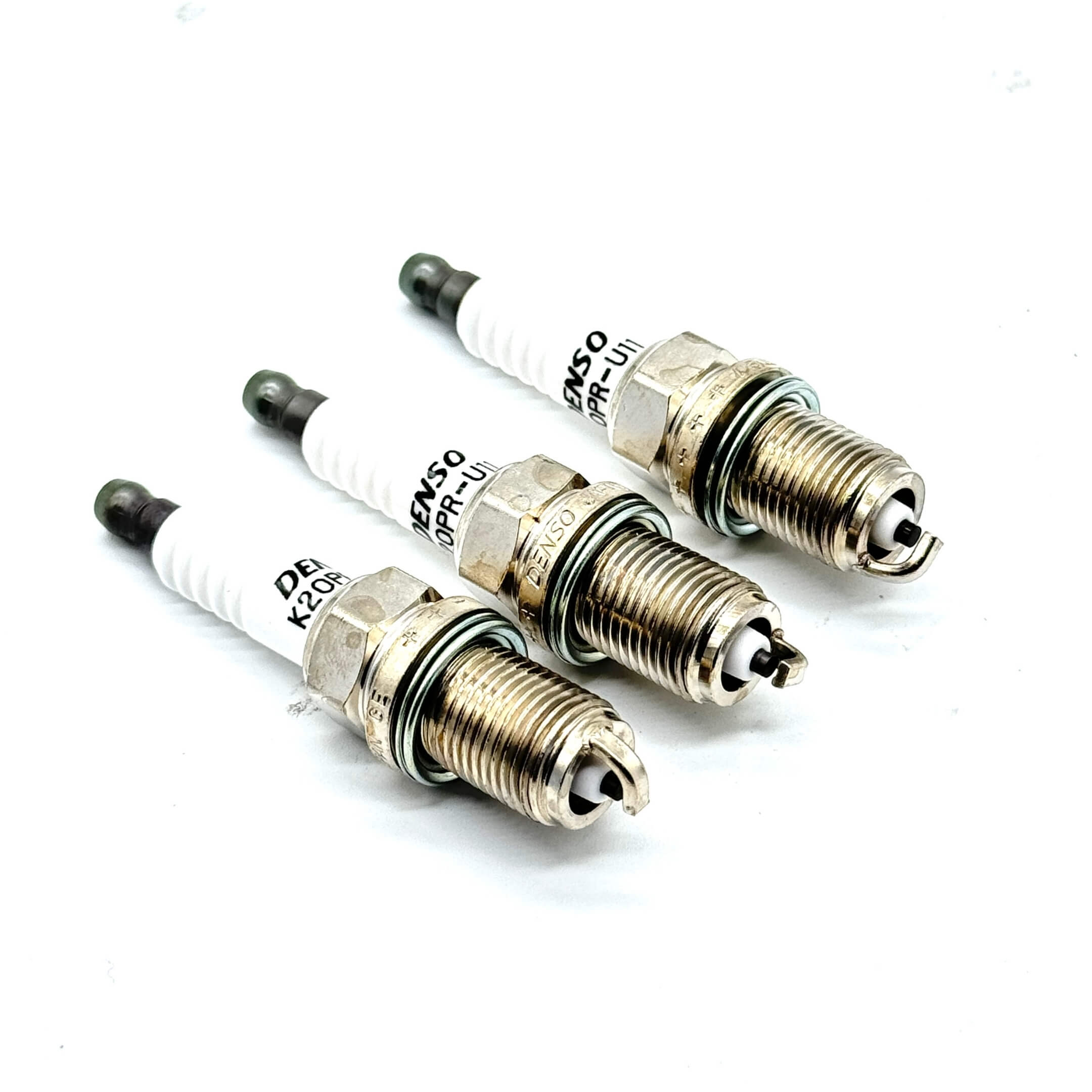 Close-up of three genuine Subaru spark plugs for optimal ignition performance.