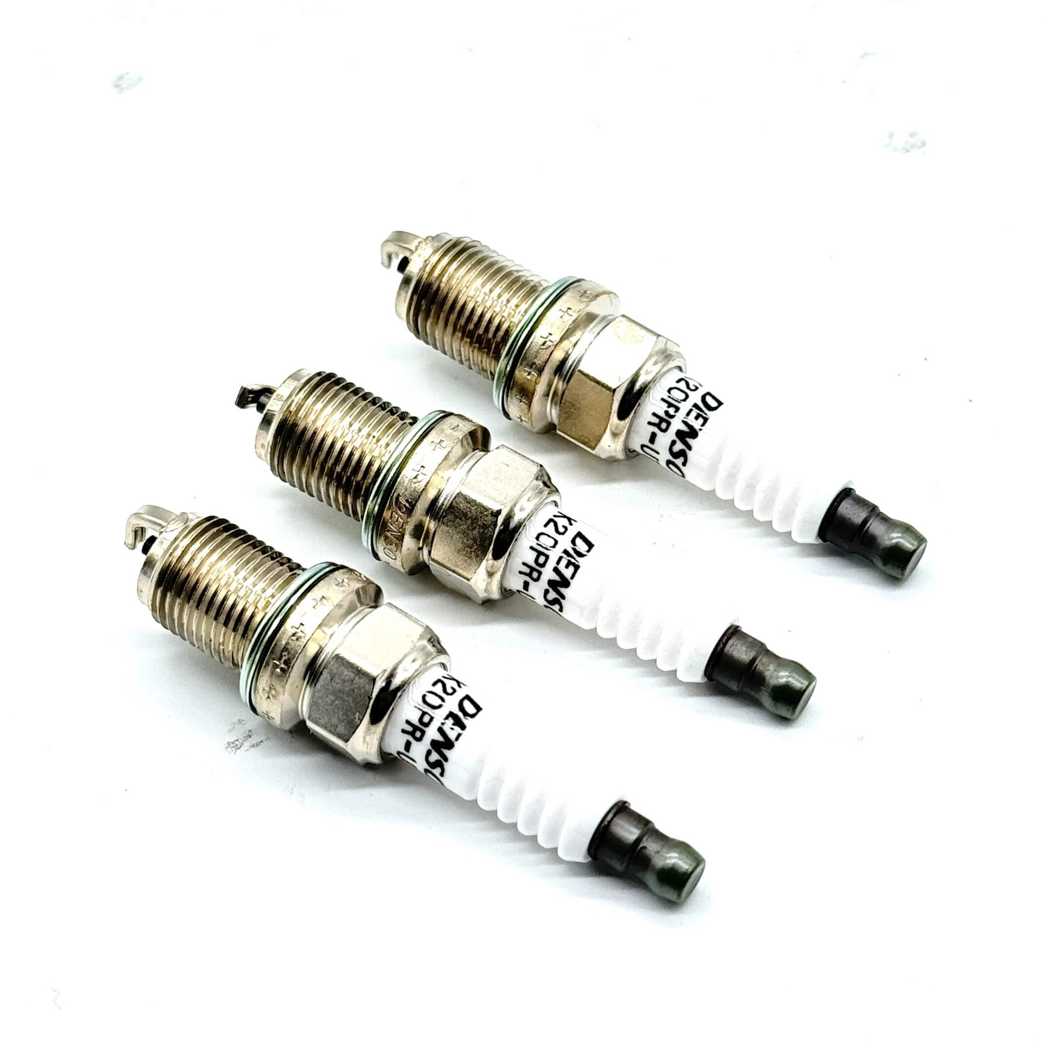 Angled view of three genuine Subaru spark plugs highlighting precision craftsmanship.