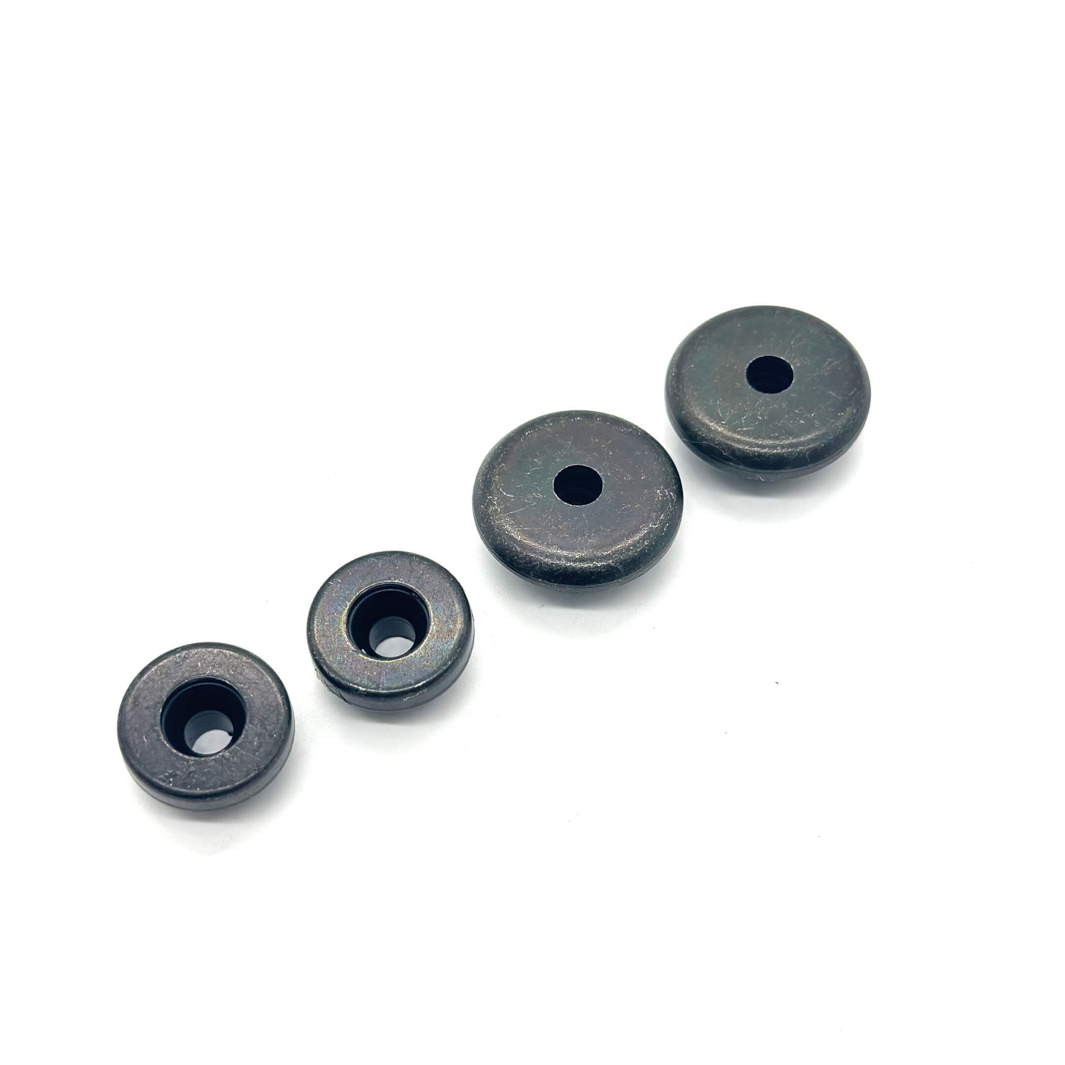 Black Valve Cover Bolt Seal Set featuring four round seals with central holes, designed for secure engine component fastening.