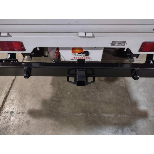 Black Suzuki Carry rear bumper with tow bar for DB52T model, 1999-2002, featuring sturdy construction and sleek design.