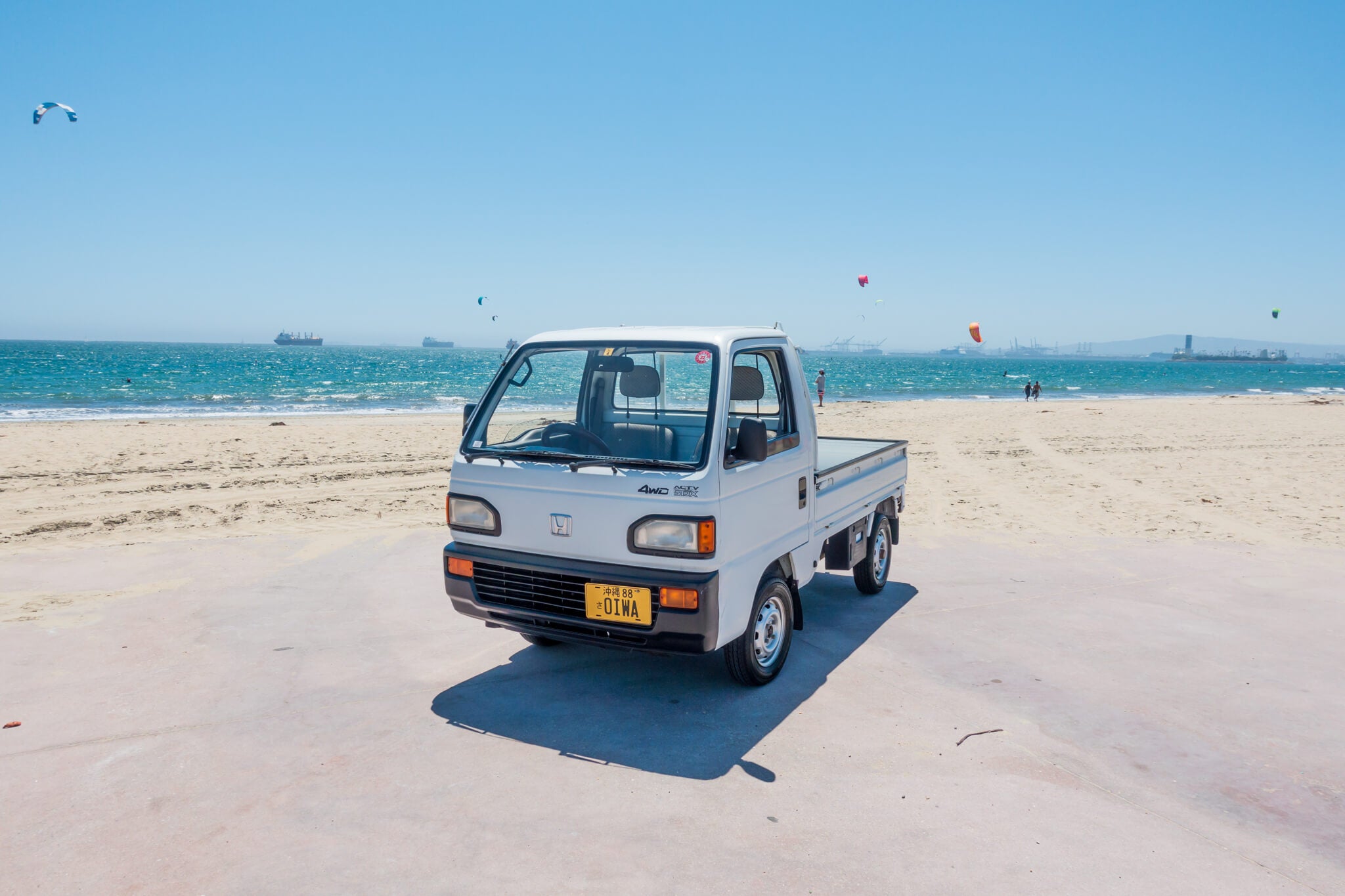 Pristine white 1992 Honda Acty HA4 mini truck parked near the beach, showcasing original features and accessories available from Oiwa Garage.
