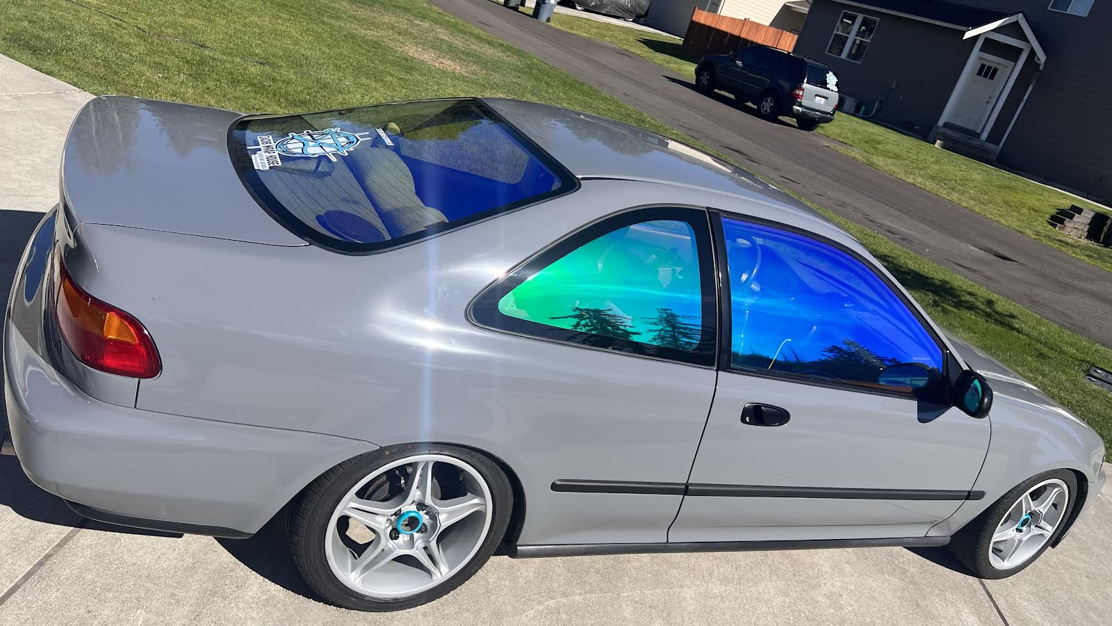 Car with Omnique Opal tint, highlighting the dynamic turquoise and blue shades on the windows.