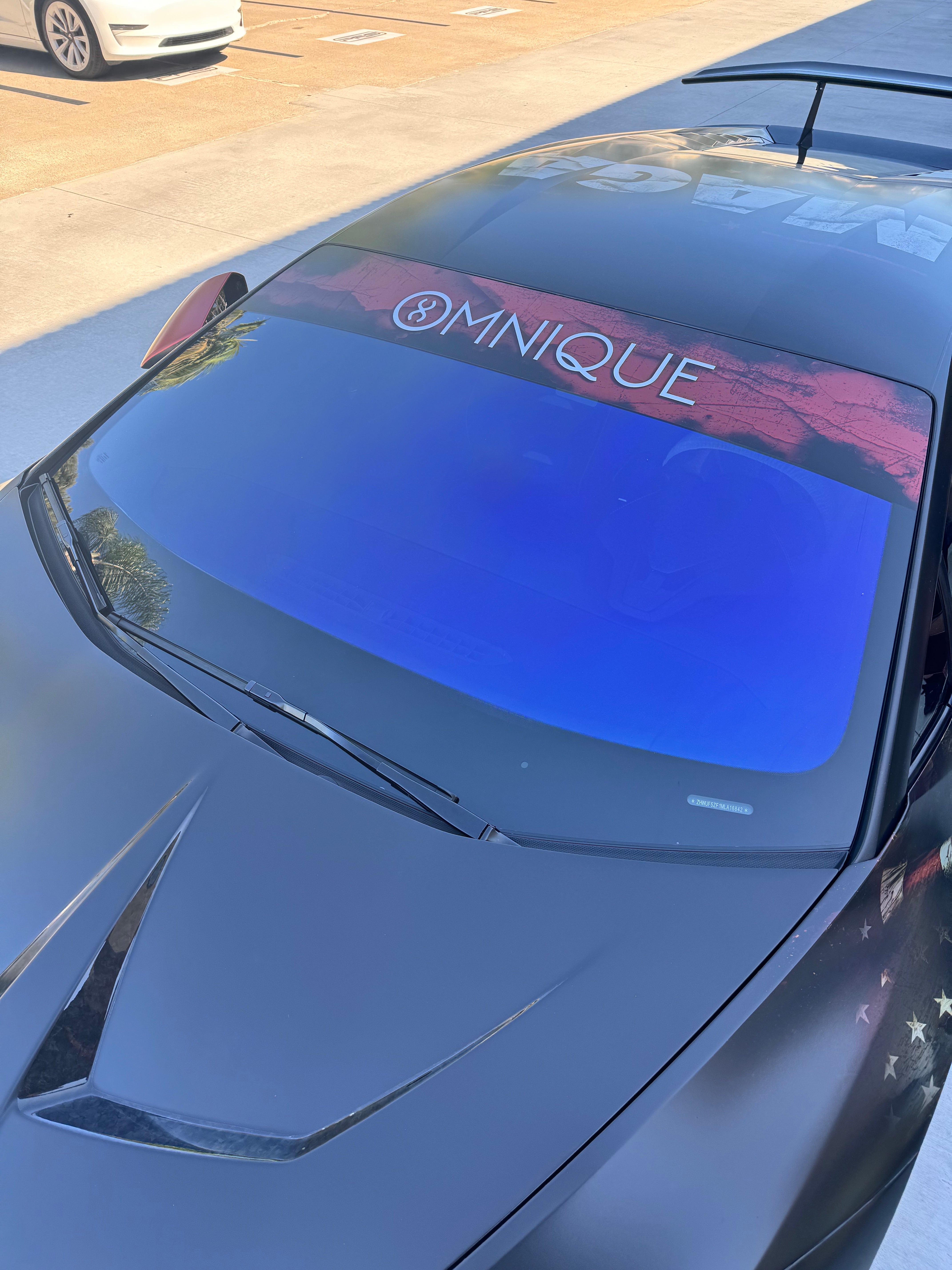 Front windshield of a car with Omnique IOLITE tint, showcasing clear blue and purple color shift.