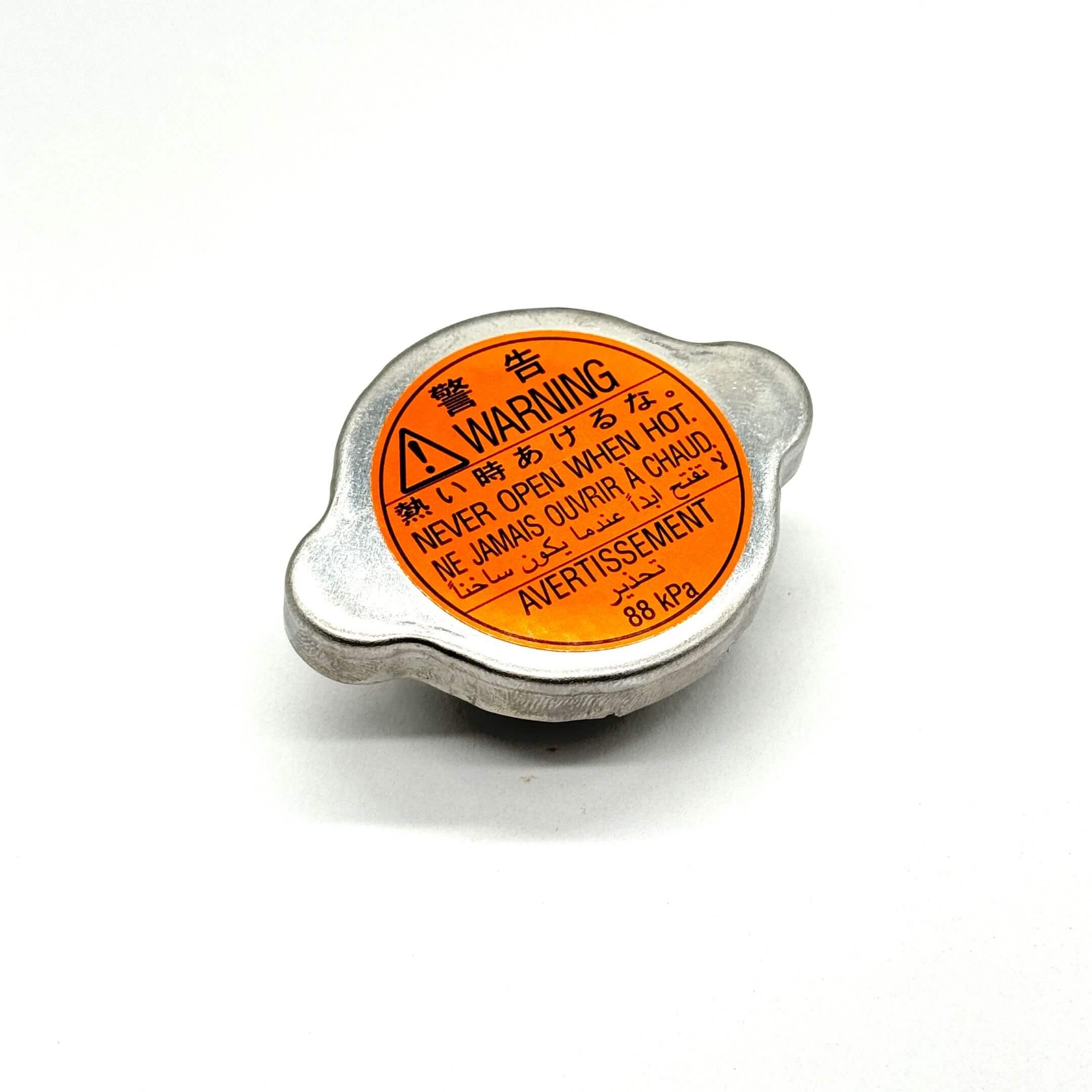 Genuine Subaru Sambar Wagon TW1, TW2 radiator cap for 1999-2012 models, featuring a silver finish with an orange warning label.
