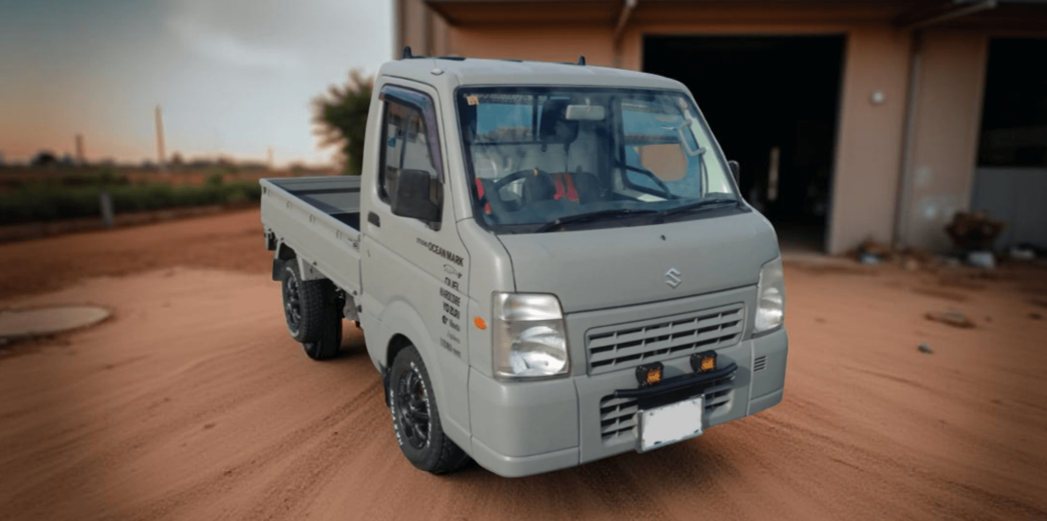 Customized Suzuki Carry Truck DA65T (2005-2013) in Matte Gray with Off-Road Tires, Aftermarket Wheels, and Front Bumper LED Lighting – Kei Truck Upgrades