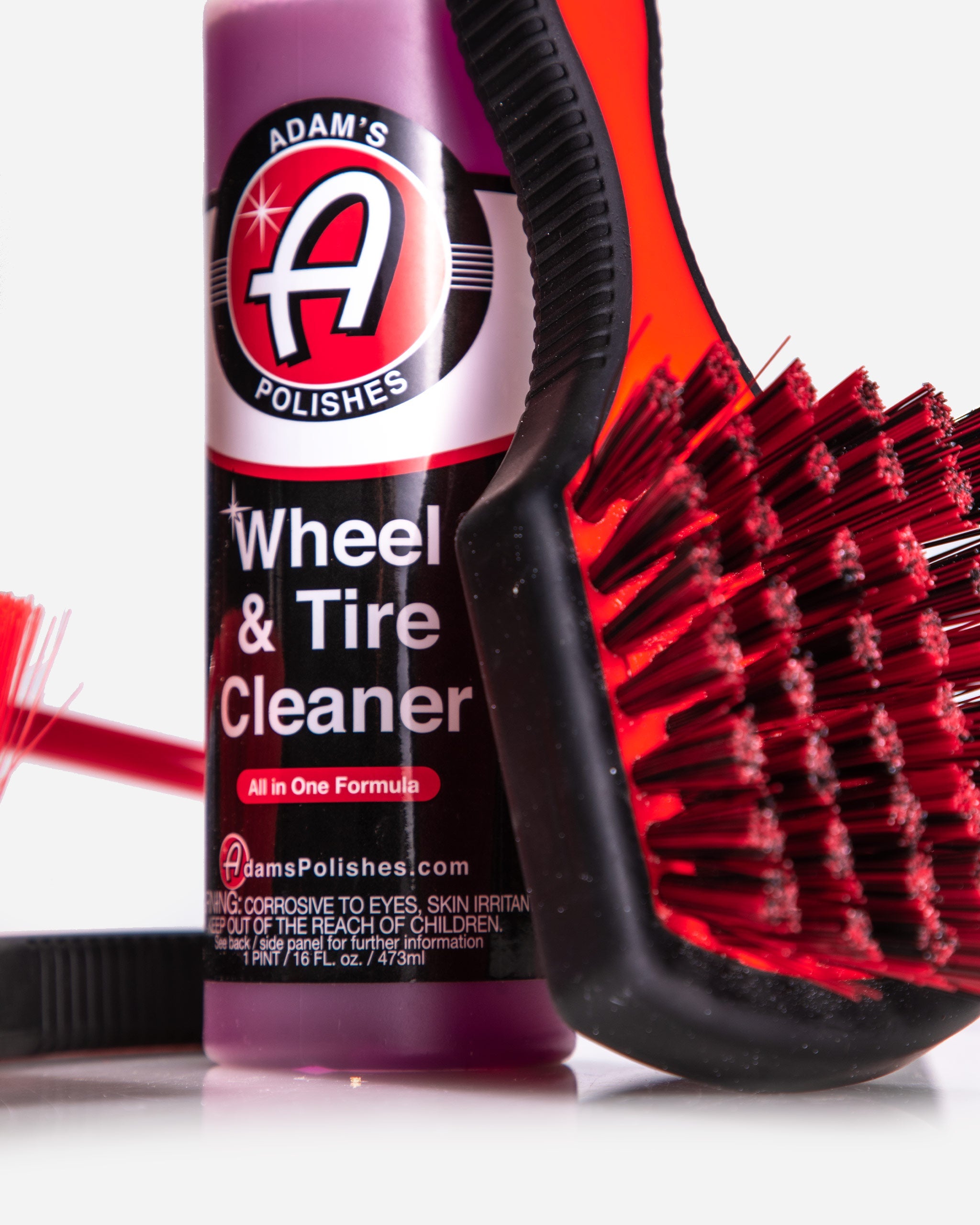 Adam’s Polishes Best Wheel and Tire Cleaner alongside a rubberized brush, demonstrating the Basic Kit’s safe and powerful formula for OEM & stock wheels Adam's Polishes