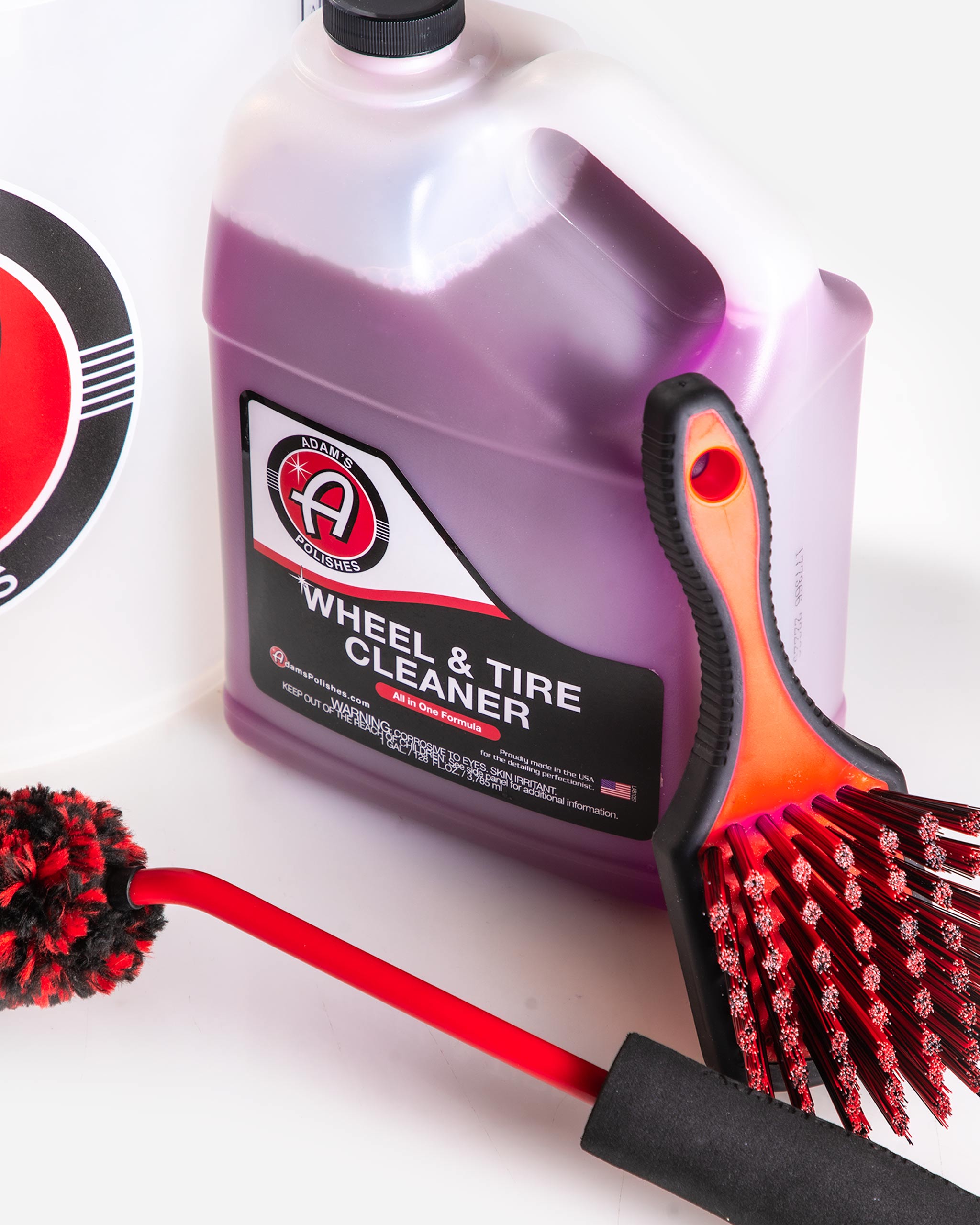 Close-up of Adam’s Polishes Wheel & Tire Cleaner gallon and rubberized brush from the Best Wheel Cleaner Complete Kit, perfect for safe cleaning of stock wheels.