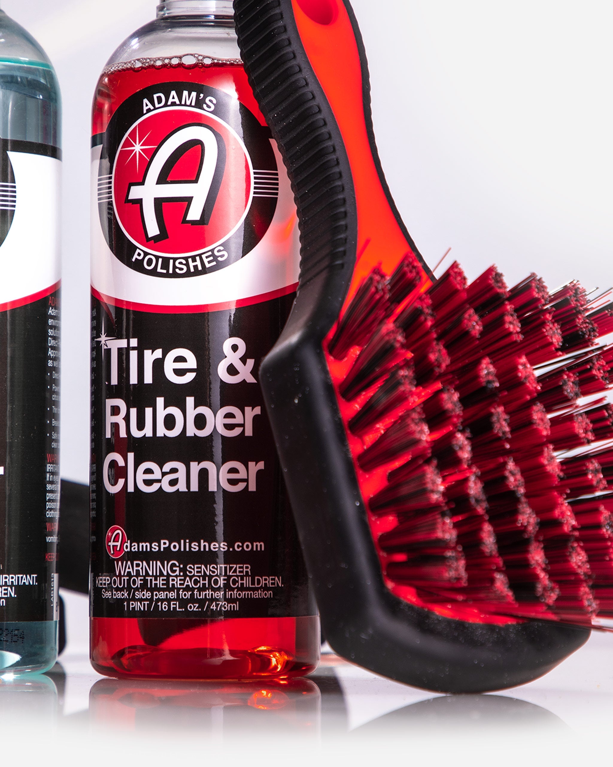 Close-up of Tire & Rubber Cleaner from Adam’s Polishes Best Wheel Cleaner Basic Kit, paired with a rubberized brush for gentle wheel and tire care.