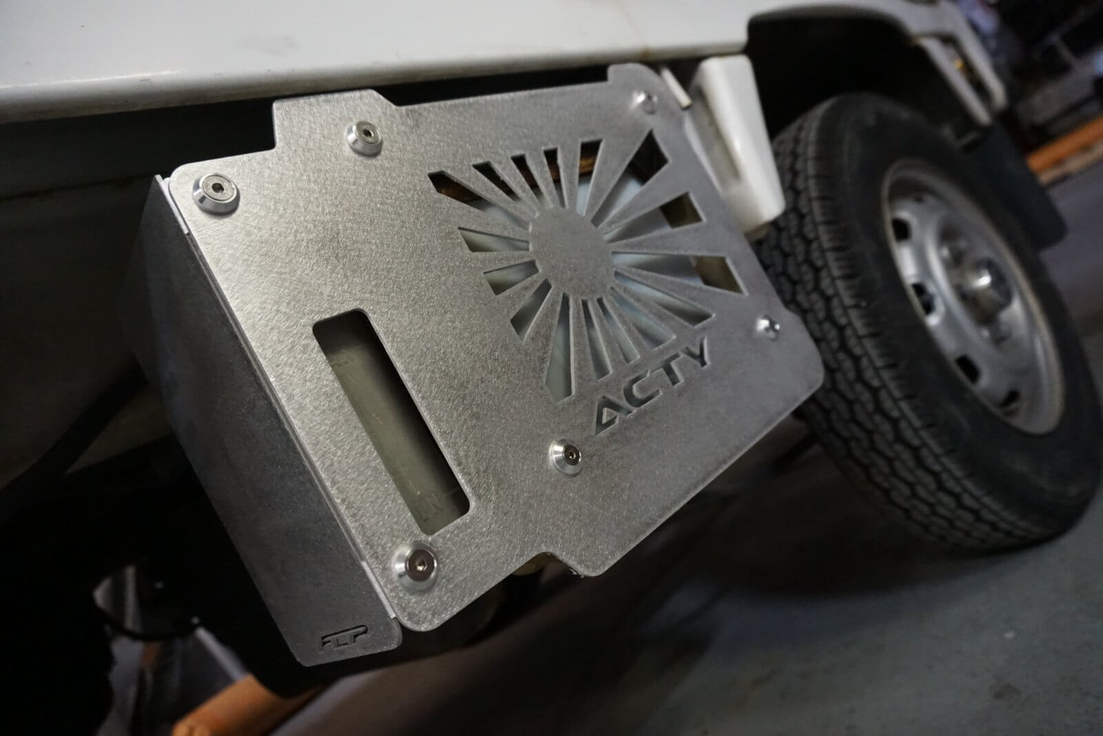 Rising Sun Battery Cover for Honda Acty Truck, silver aluminum with cutout design, mounted on vehicle side, textured finish