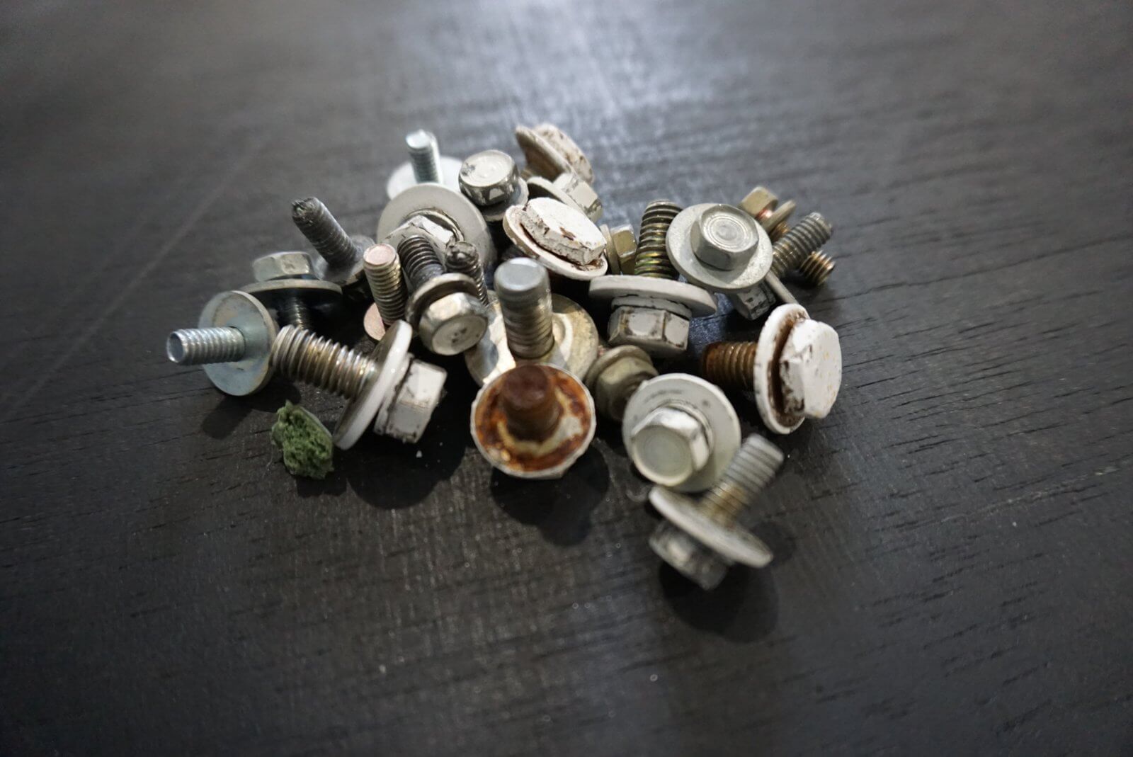 Stainless Bed Bolt Kit for Honda Acty Truck, featuring various bolts and washers, displayed on a dark wooden surface