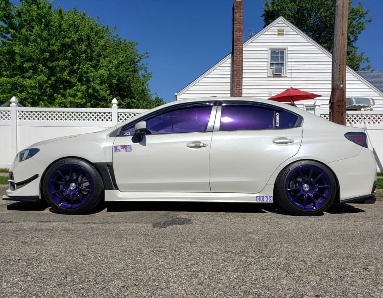 White Sedan with Omnique Amethyst Purple Tint – Ultra-dark Omnique purple tint on a white sedan for maximum privacy and heat reduction.