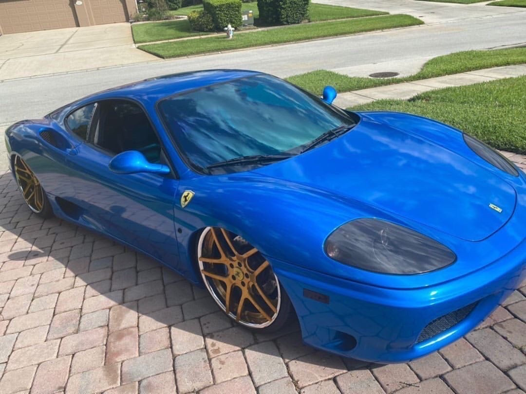 Ferrari with Omnique Zircon Tint, showing the car’s refined blue window tint.