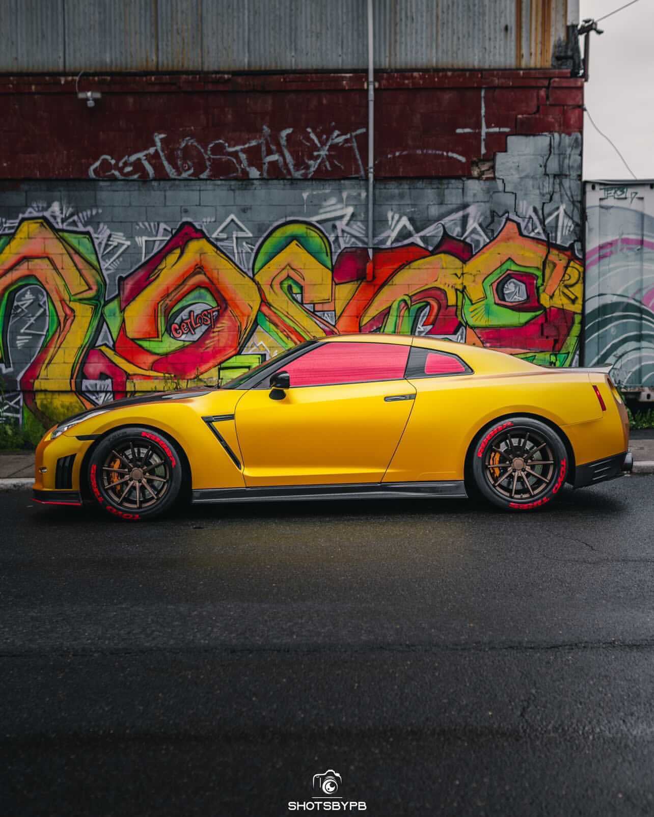 Omnique Vulcan Red tint applied to the windshield of a custom-tuned car with high-performance upgrades.
