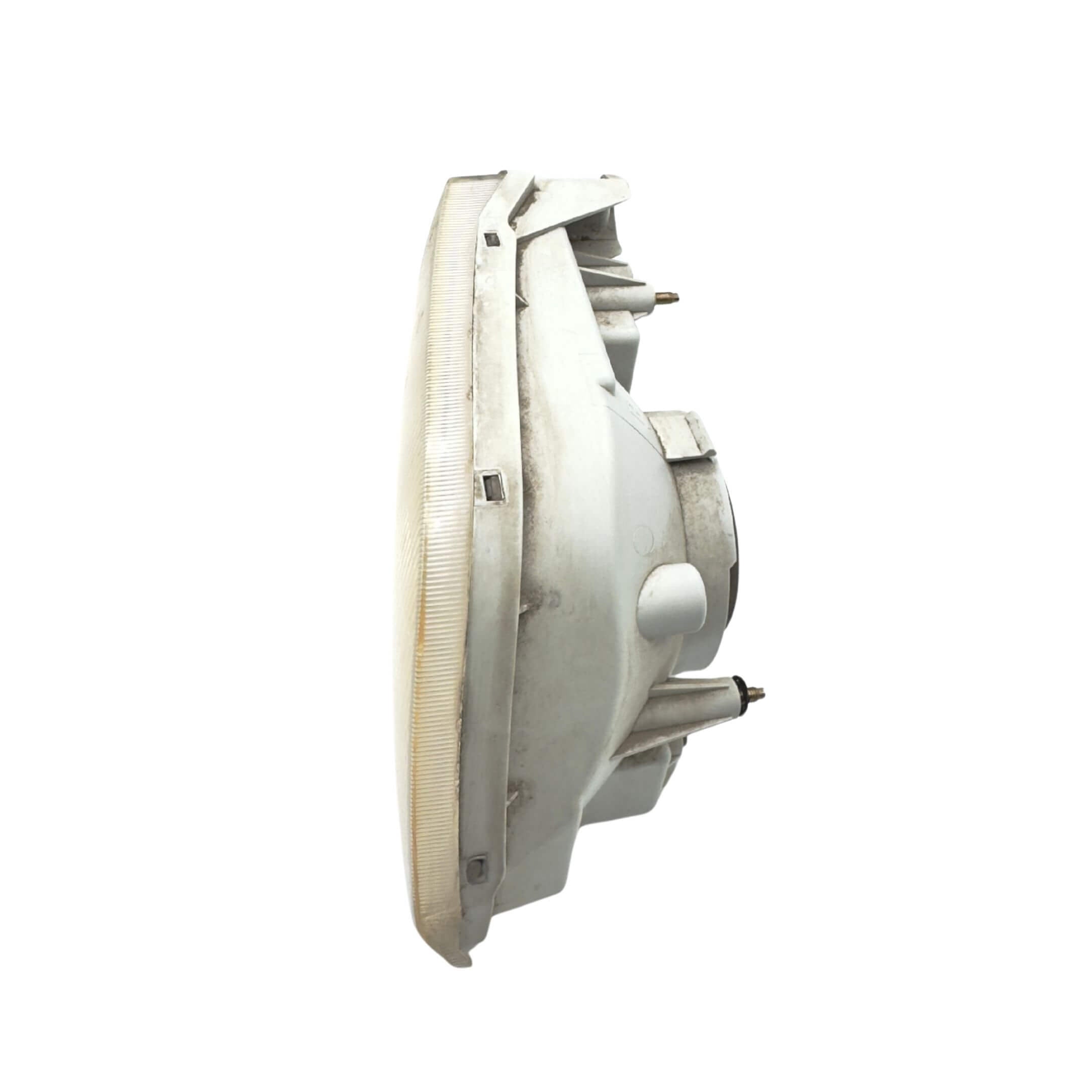 Used left passenger side headlight for Subaru Sambar Truck TT1, TT2 models (2002-2012) featuring a clear lens and mounting brackets.