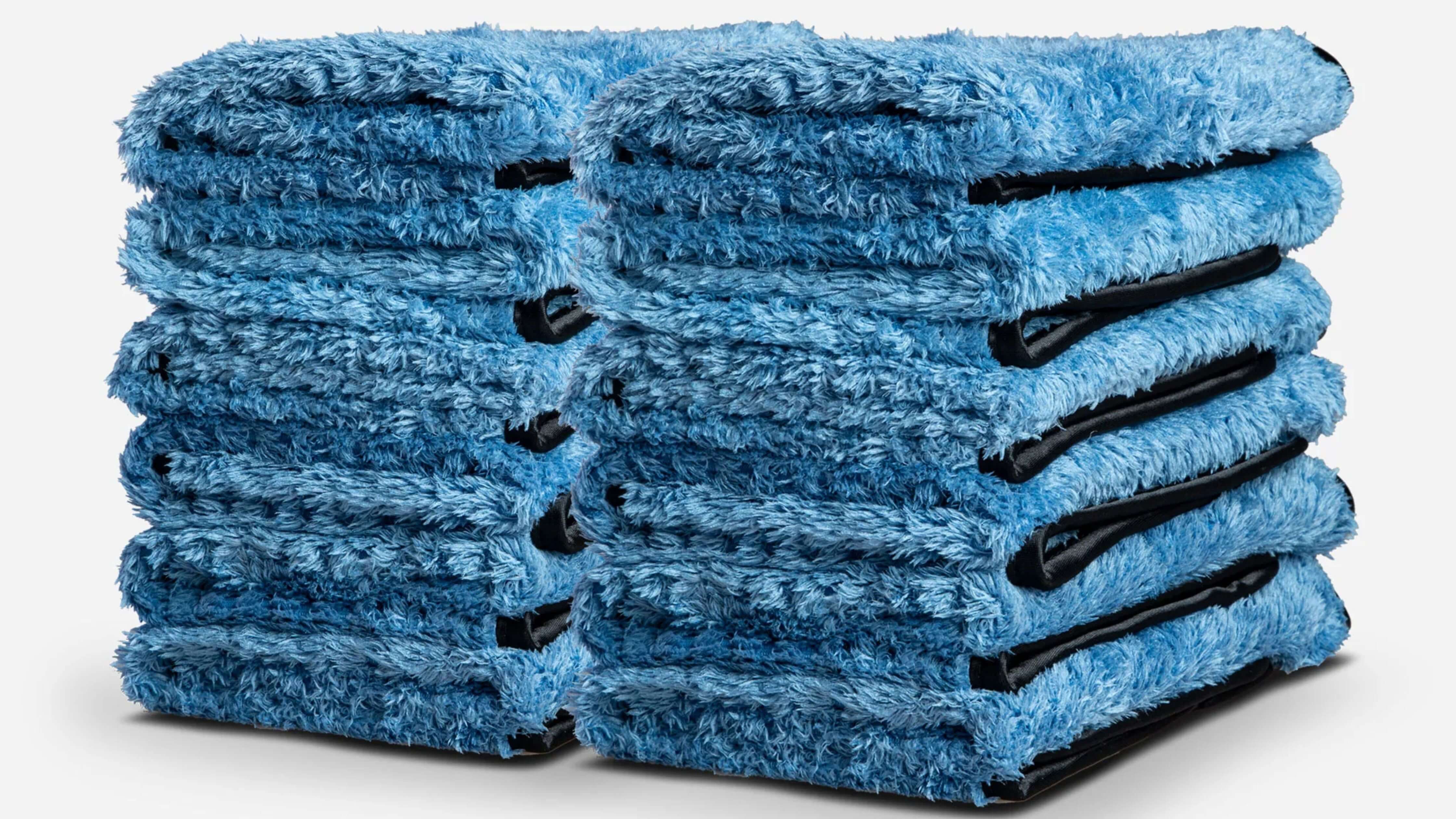 Two stacks of folded blue microfiber towels with black edges.