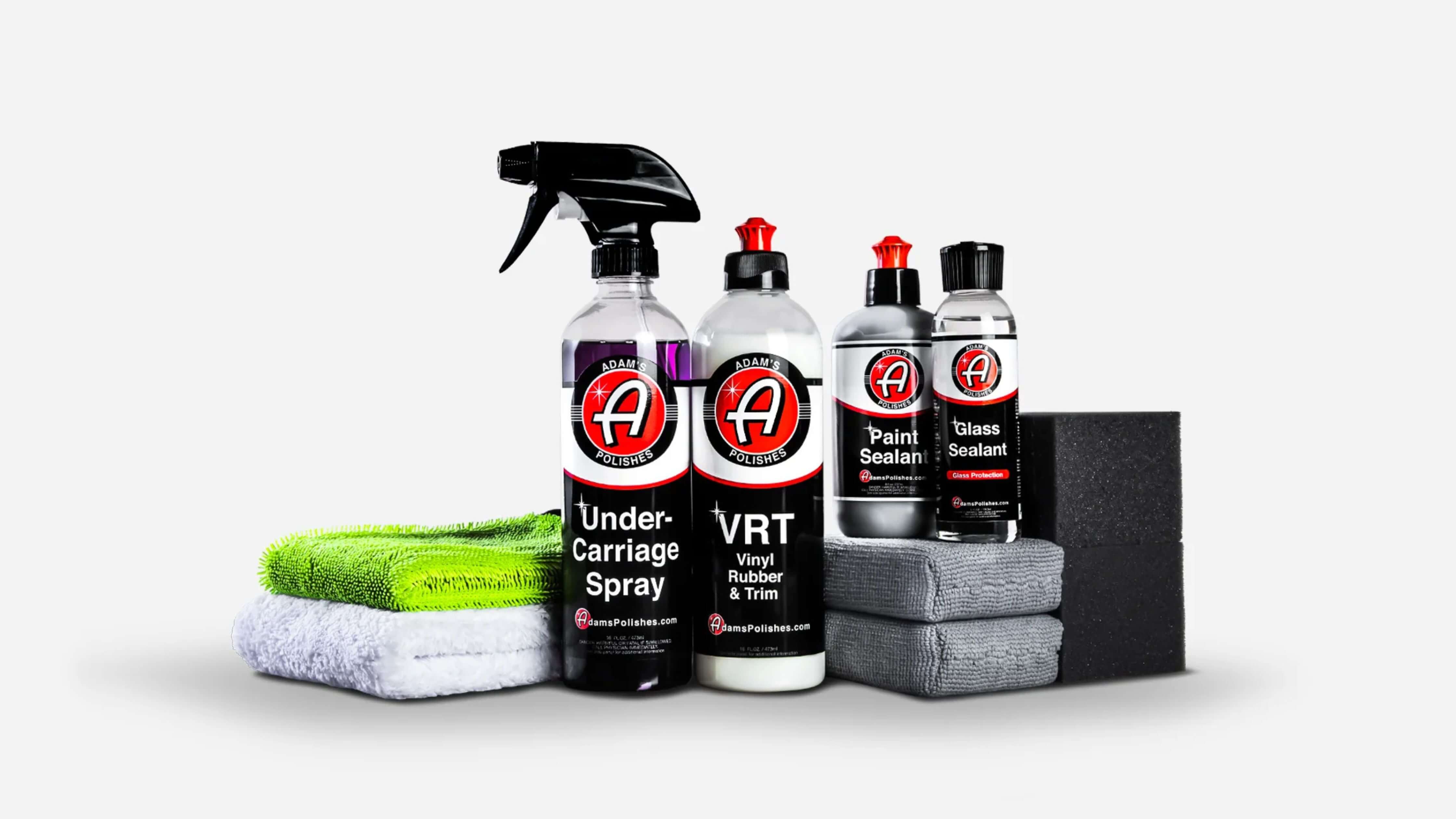 A collection of Adam's Polishes car care products, including undercarriage spray, VRT, paint sealant, and glass sealant, alongside microfiber towels and sponges.