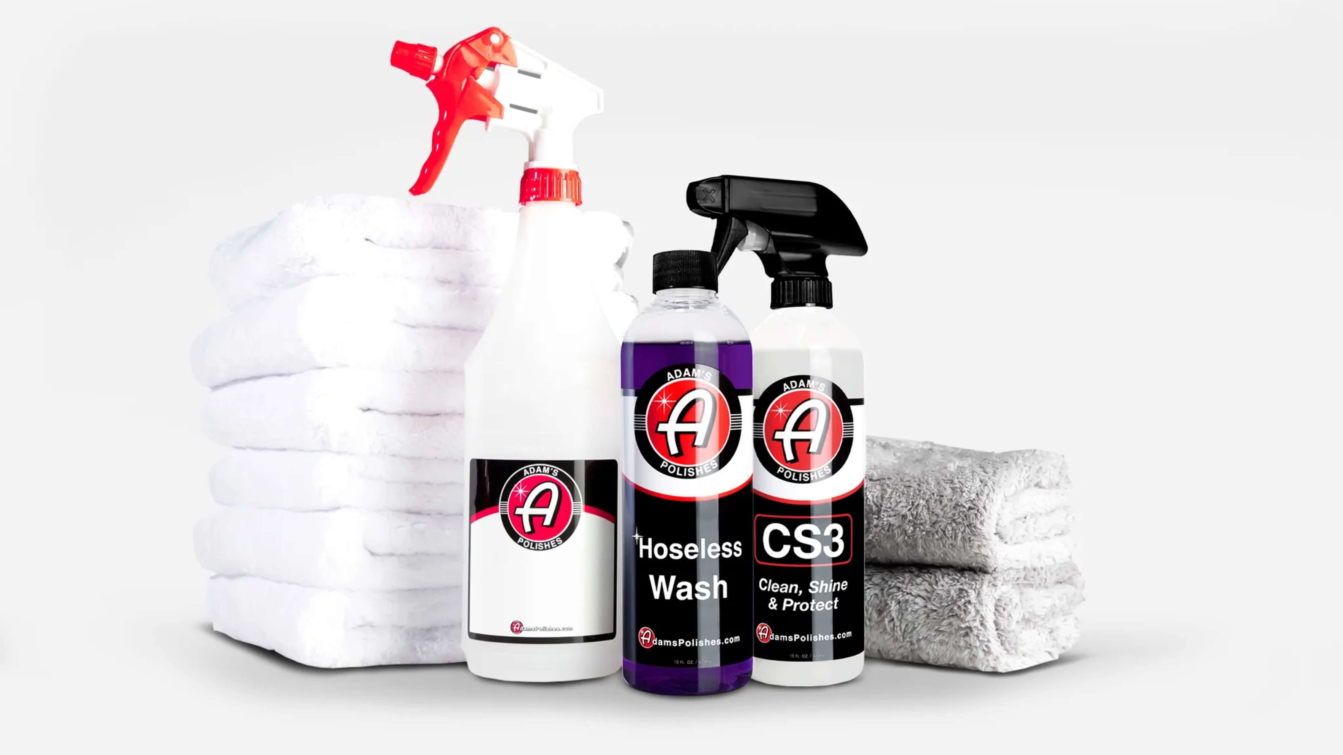 Three bottles of Adam's Polishes cleaning products displayed with white and gray towels.