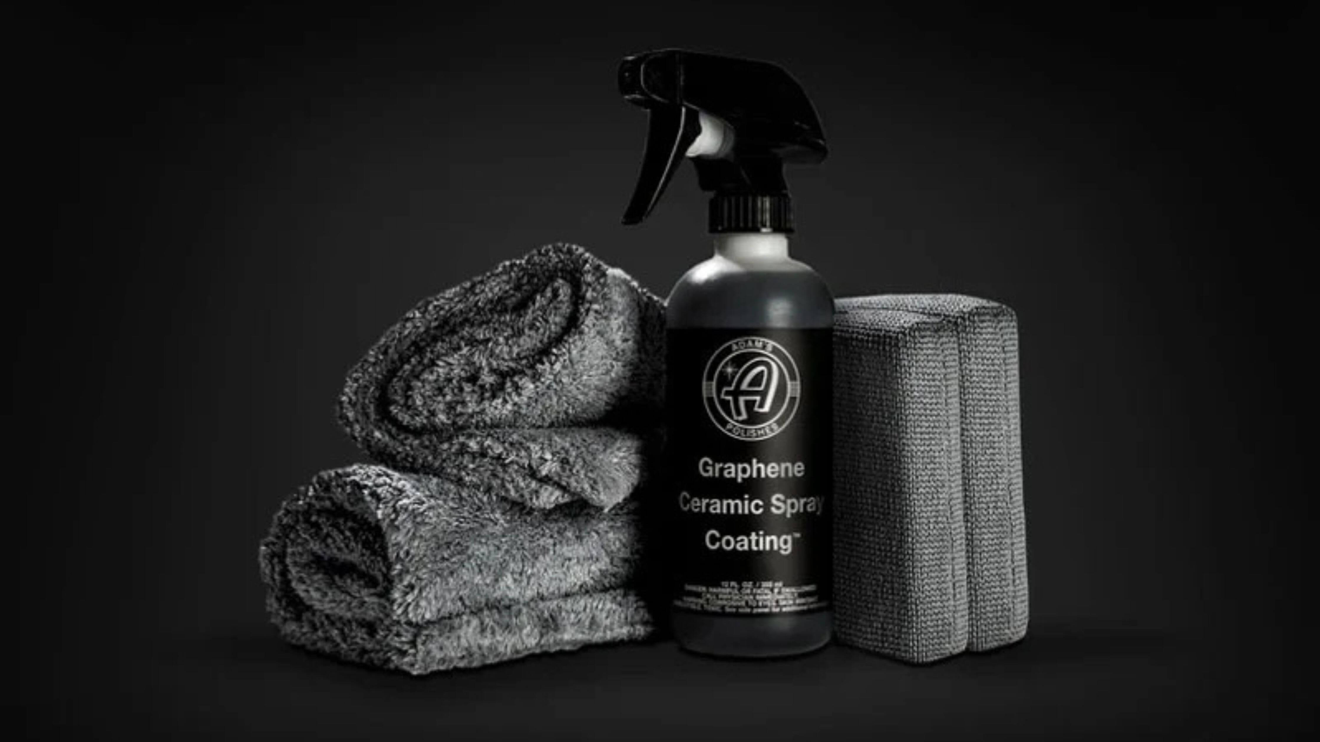 Bottle of ceramic car wash soap by Adam's Polishes with gray towels and sponge.
