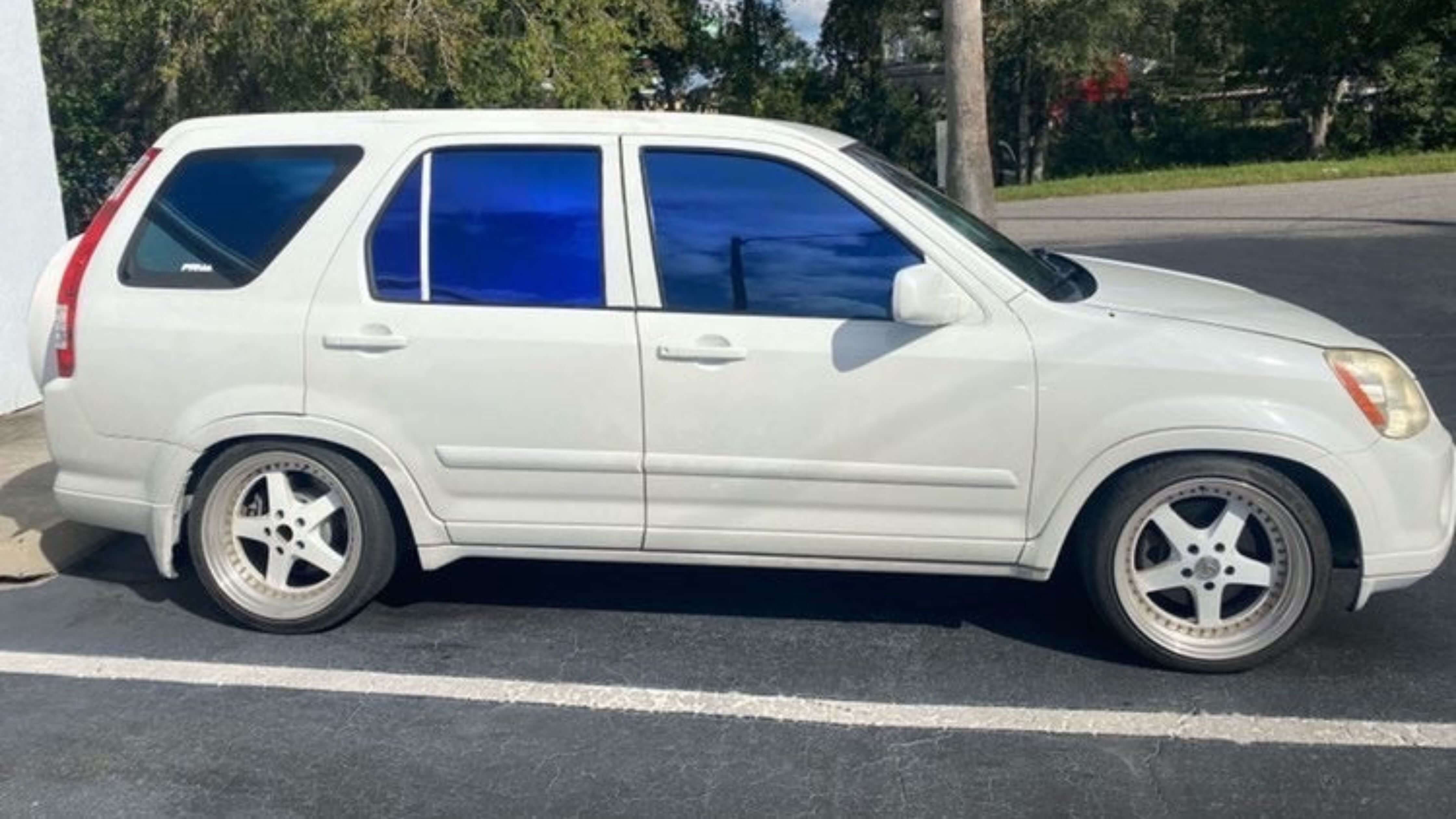 White SUV with blue-tinted windows illustrating car window tinting.