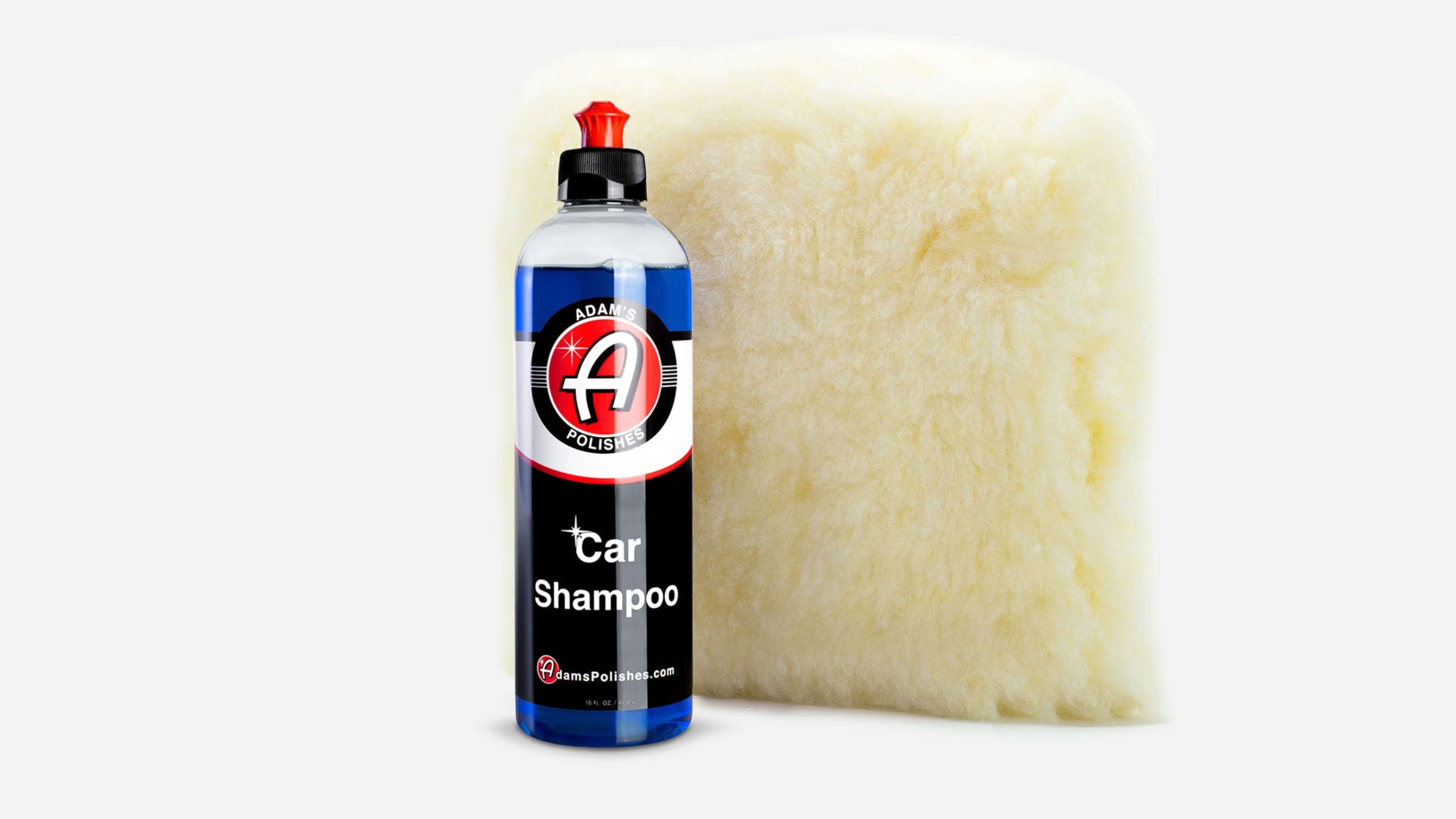 A bottle of Adam's Polishes Car Shampoo next to a large, fluffy sponge, showcasing the best car wash foam soap.