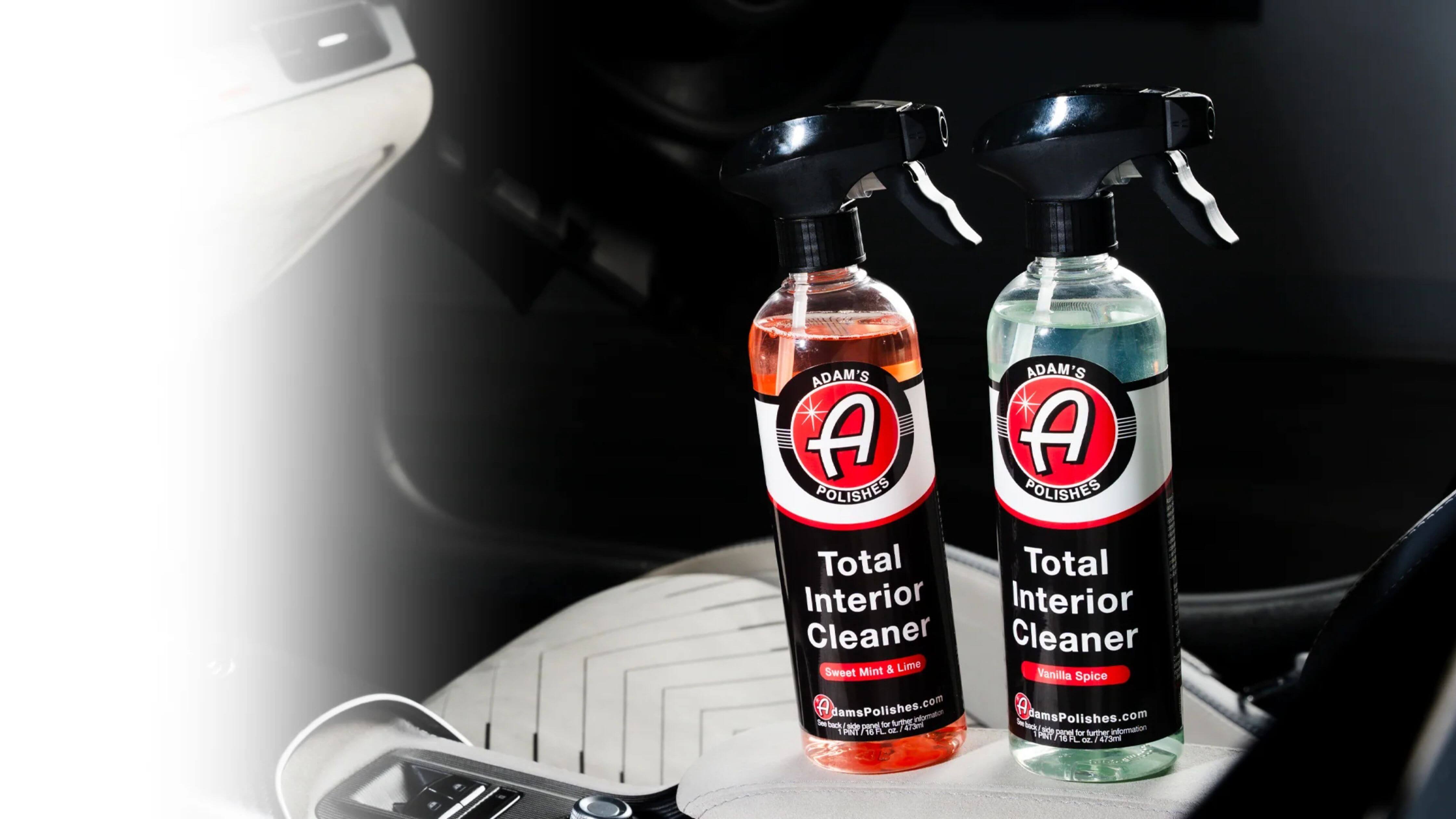 Two bottles of Adam's Polishes Total Interior Cleaner on a car seat, showcasing their Sweet Mint & Lime and Vanilla Spice variants.