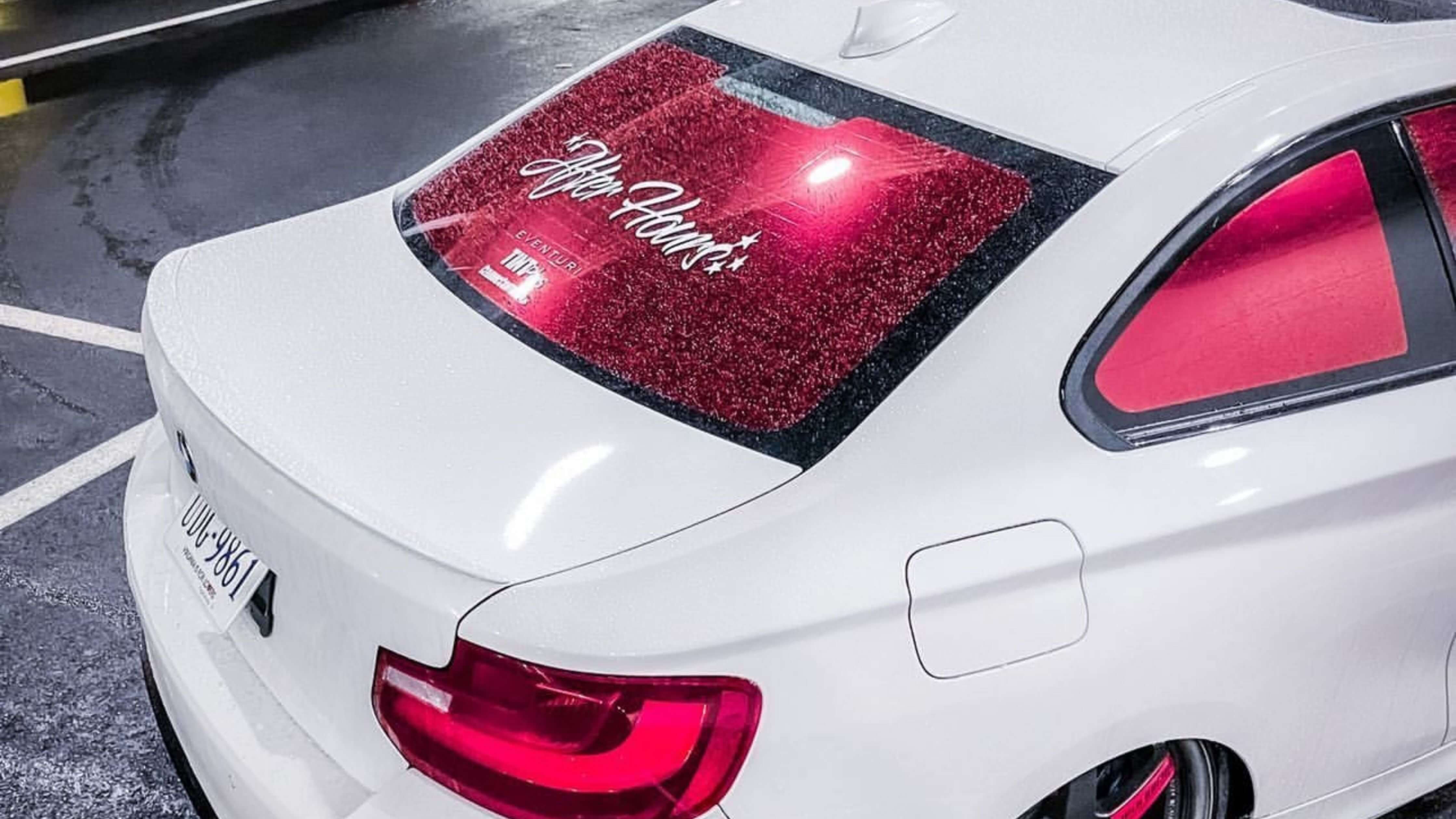 White car with red-tinted rear window displaying 'After Hours' and license plate 'DUU-3861.'