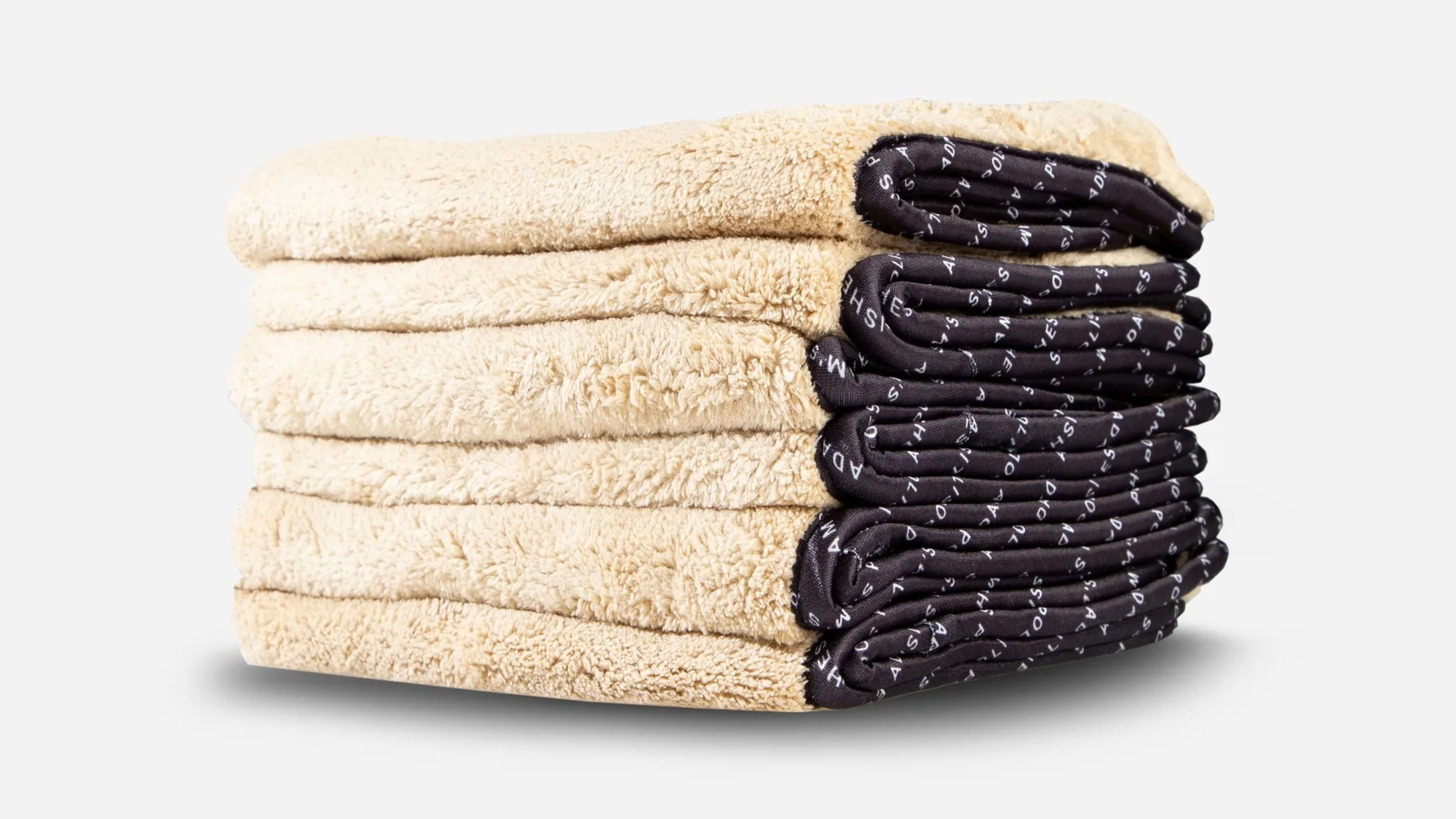 Clean folded microfiber eyeglass cloths in beige with black edges, symbolizing clarity.