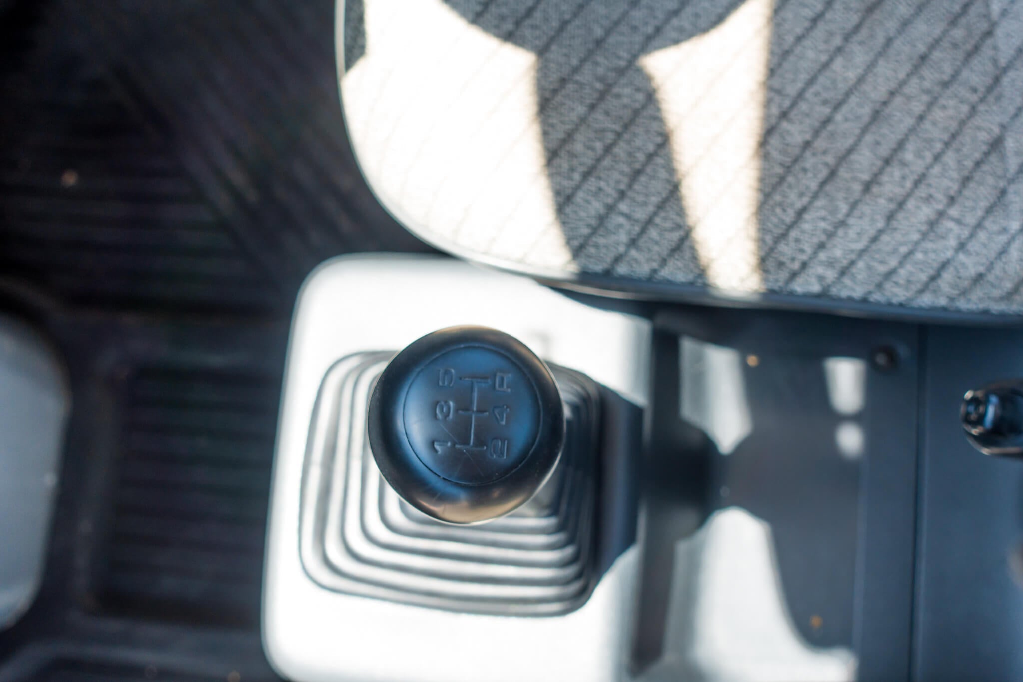 Close-up of a Honda Acty manual gear shift knob in a vehicle interior.