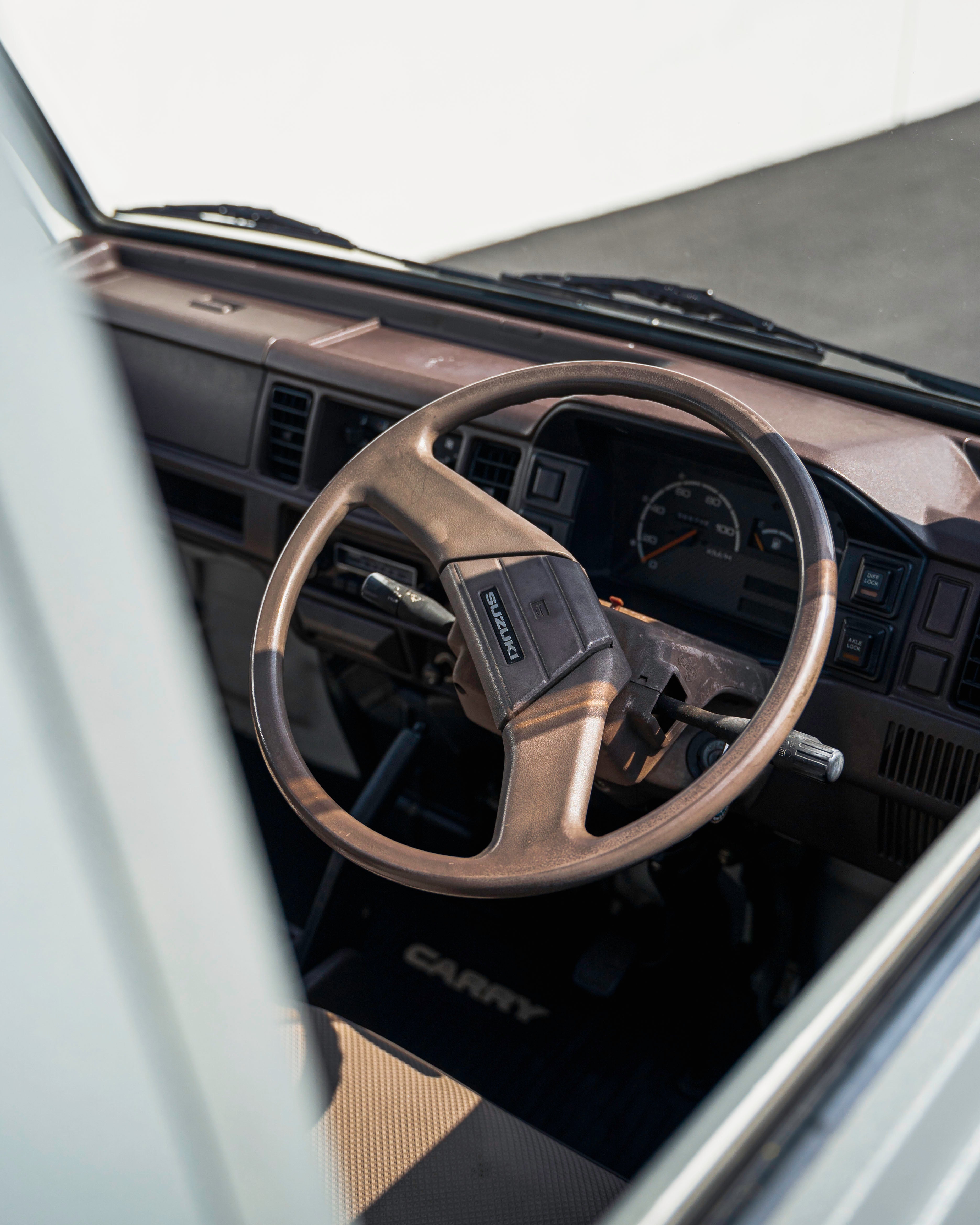 Interior view of a vehicle showing a Suzuki steering wheel and dashboard.