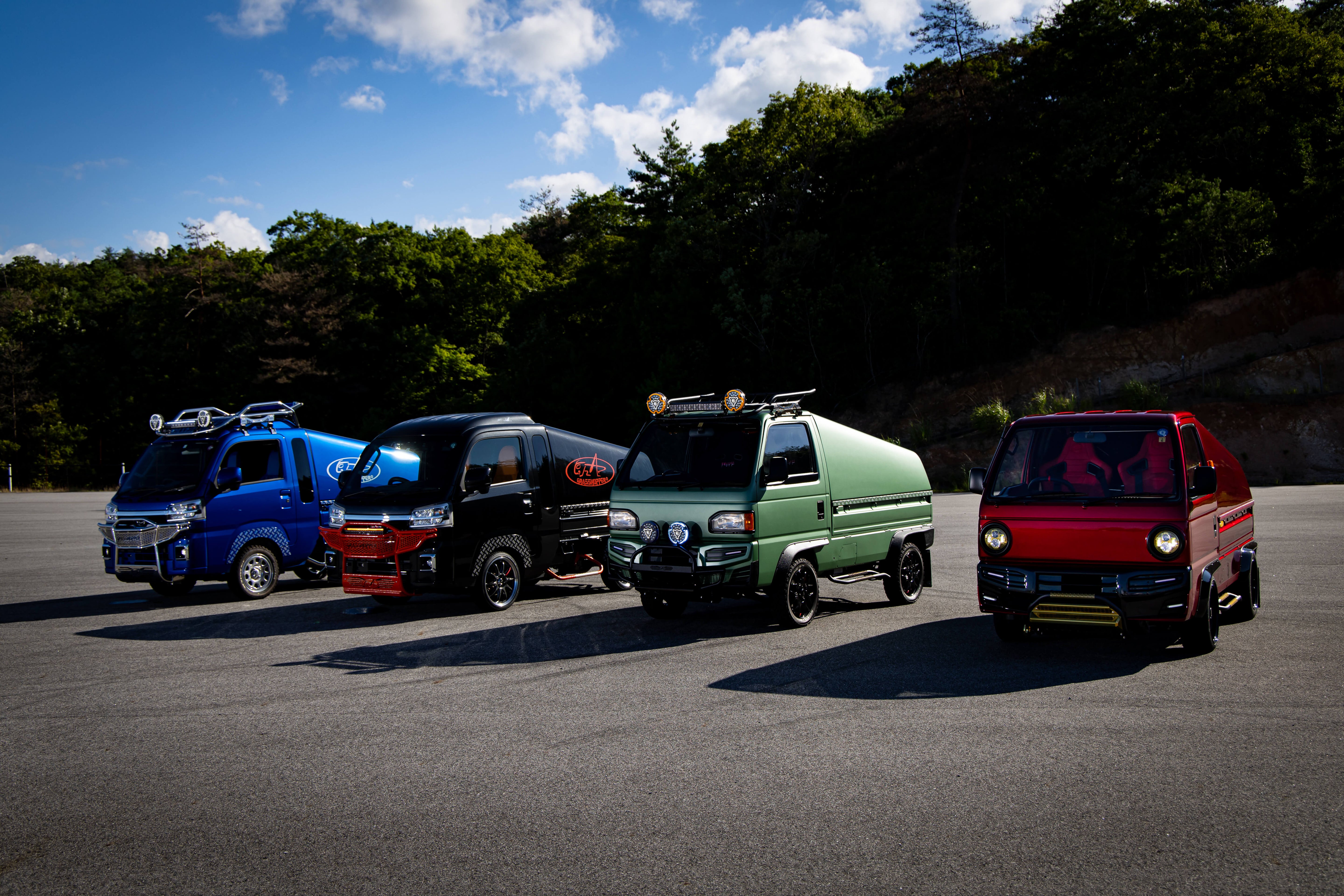 A lineup of four uniquely customized Honda Acty mini trucks, each featuring distinct paint finishes, upgraded body kits, and aftermarket accessories that highlight the endless modification potential of these popular kei trucks.