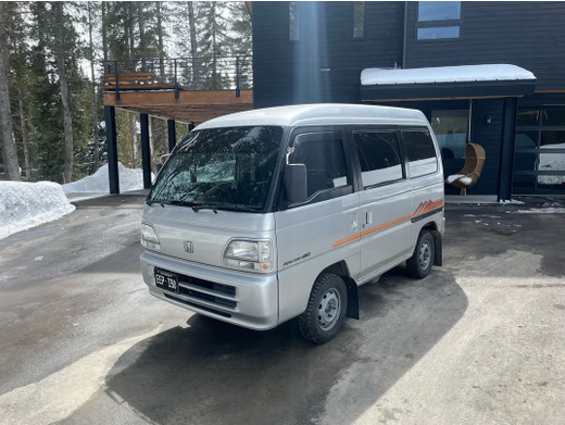 Silver Honda Street Parked in Front of a Modern House in a Snowy Environment