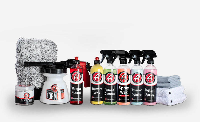Best Car Wash Soap With car detailing product kit laid out with plastic dispensers and towels.