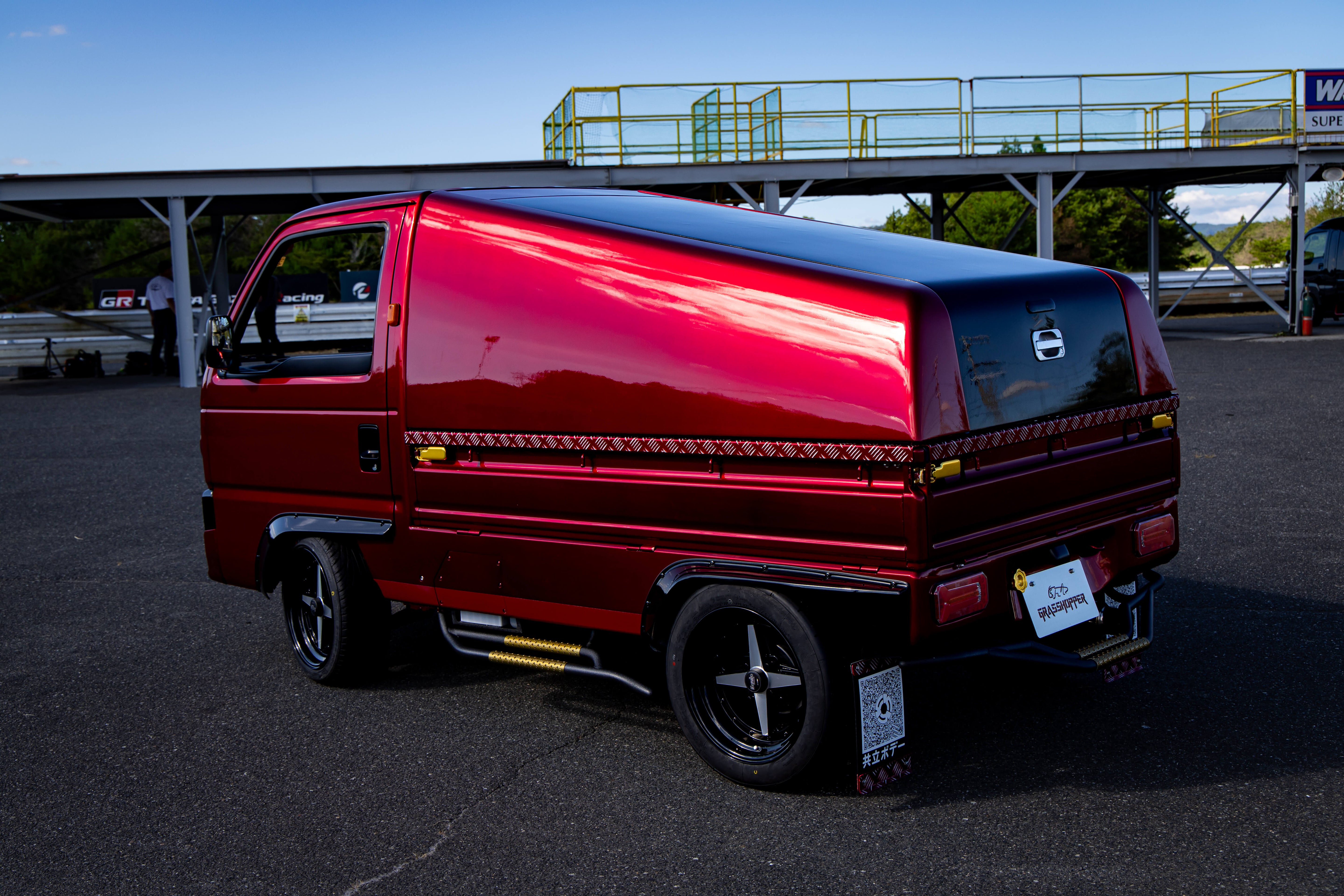 A kei truck in motion, showcasing its compact design and surprising speed capabilities in an urban setting.