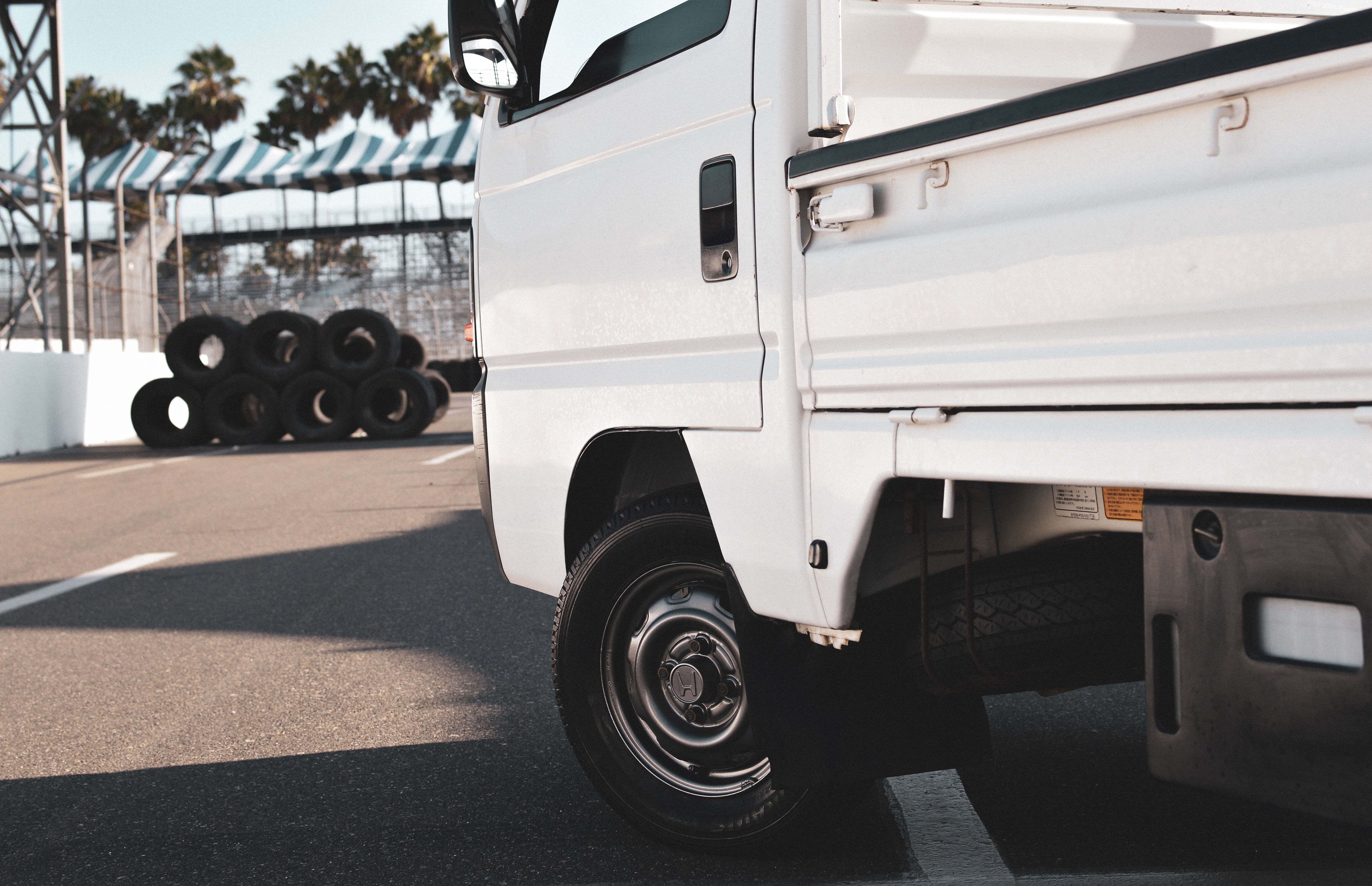 Mini truck driving through city streets, showcasing compact size and versatility.