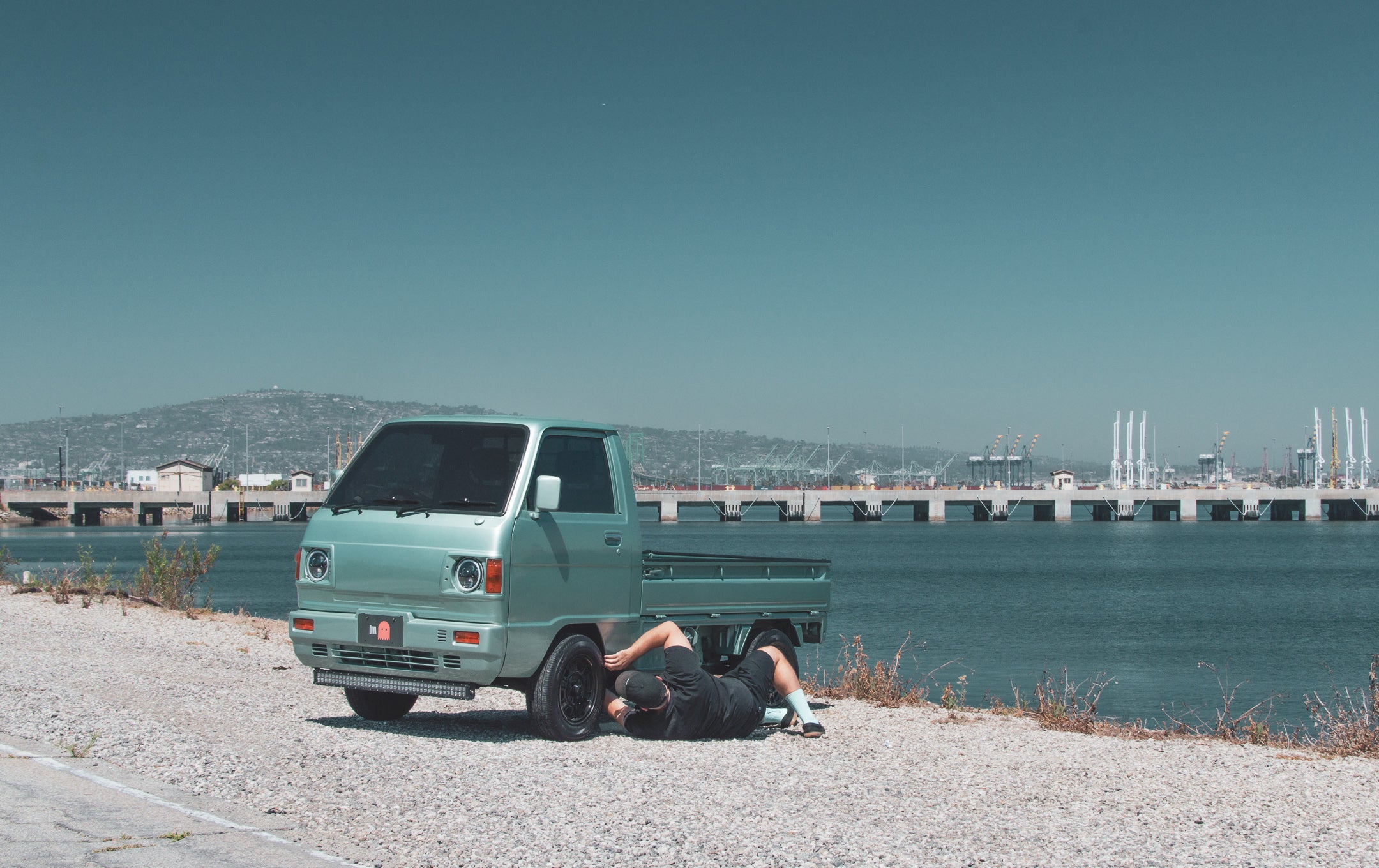 A kei truck, Japan's compact yet versatile vehicle, parked in an urban setting, showcasing its practicality and charm.