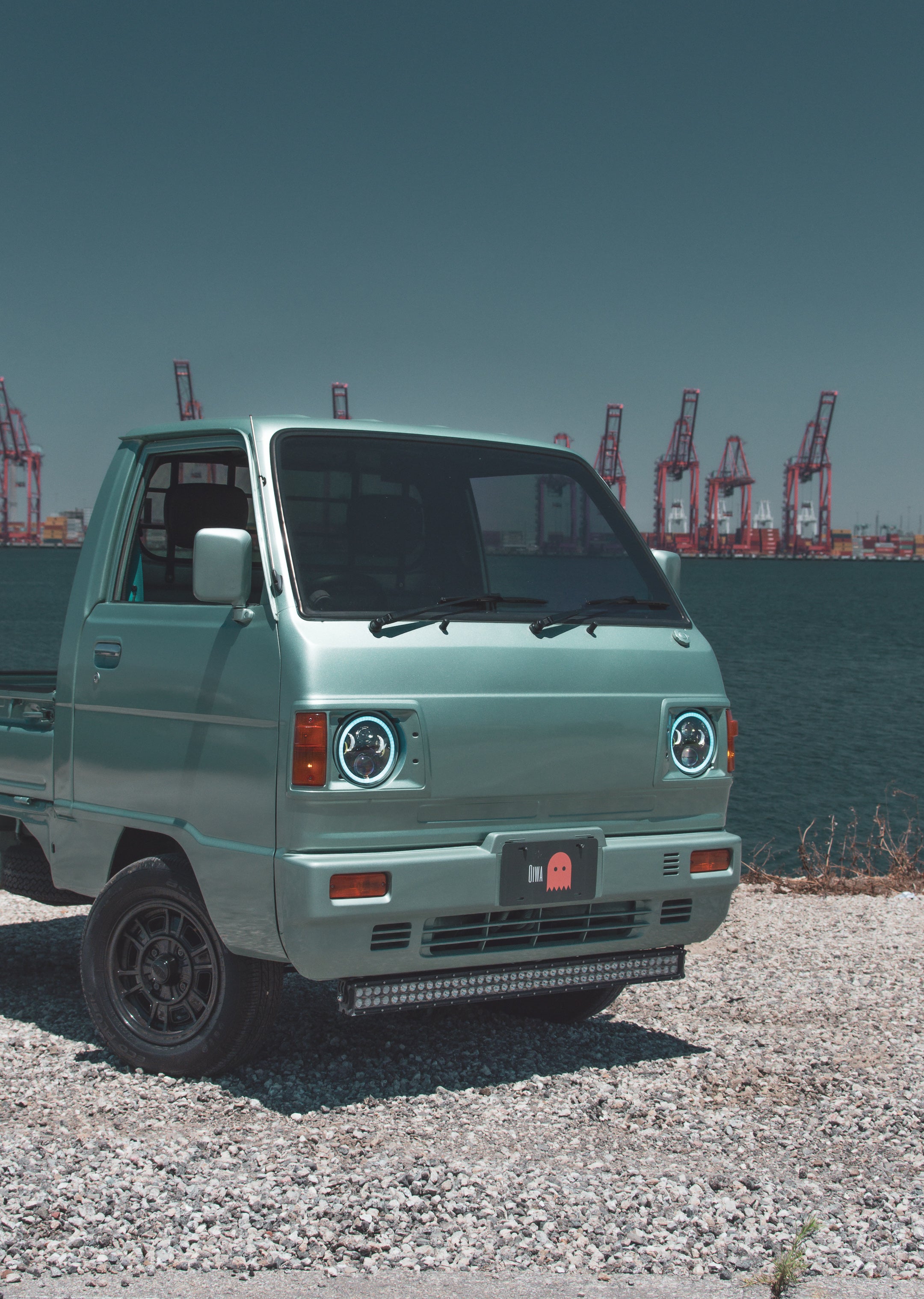 Suzuki Carry Truck parked in urban setting, showcasing compact design and utility.