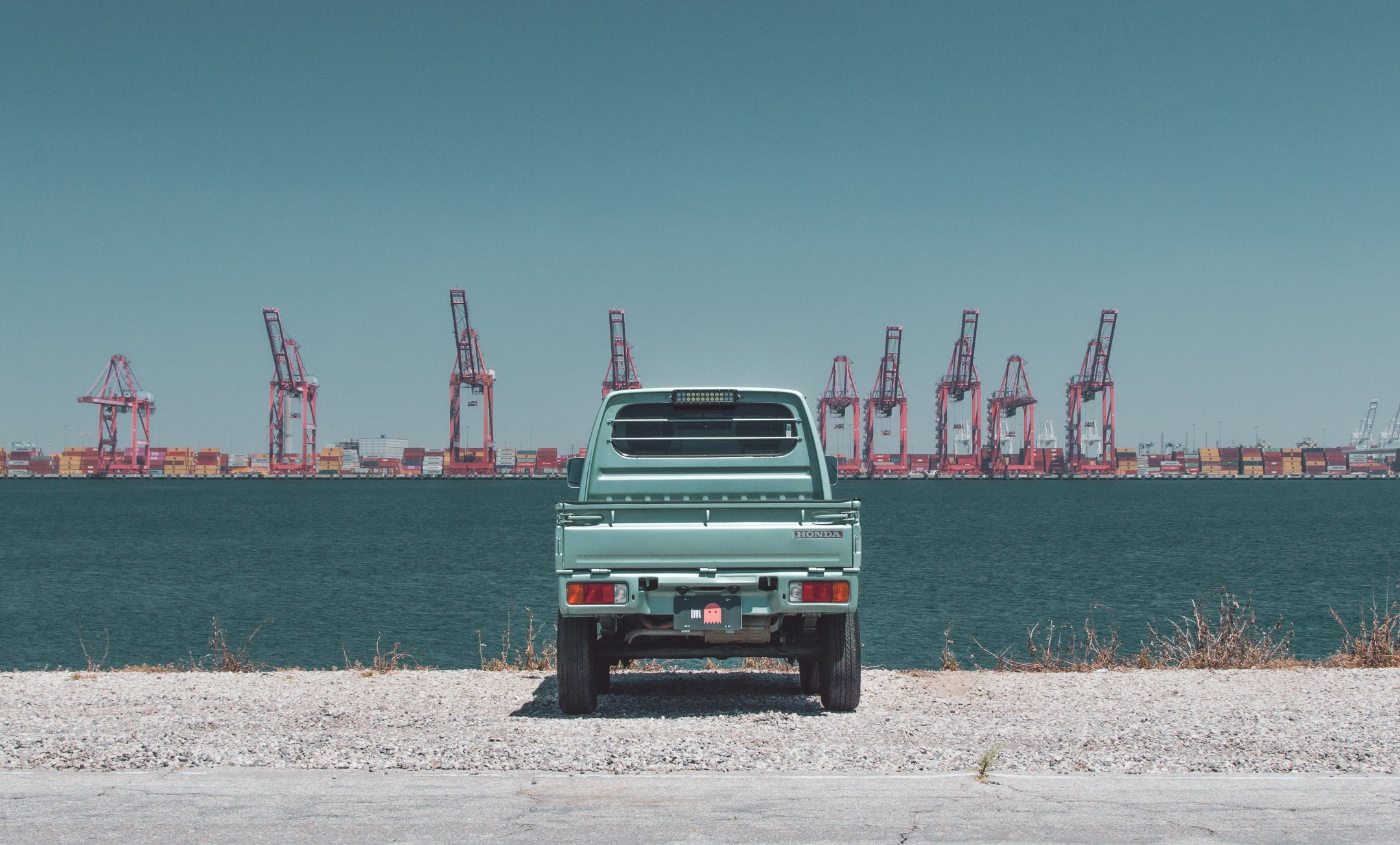 Kei truck from Japan driving on a city street, showcasing its compact design and versatility.