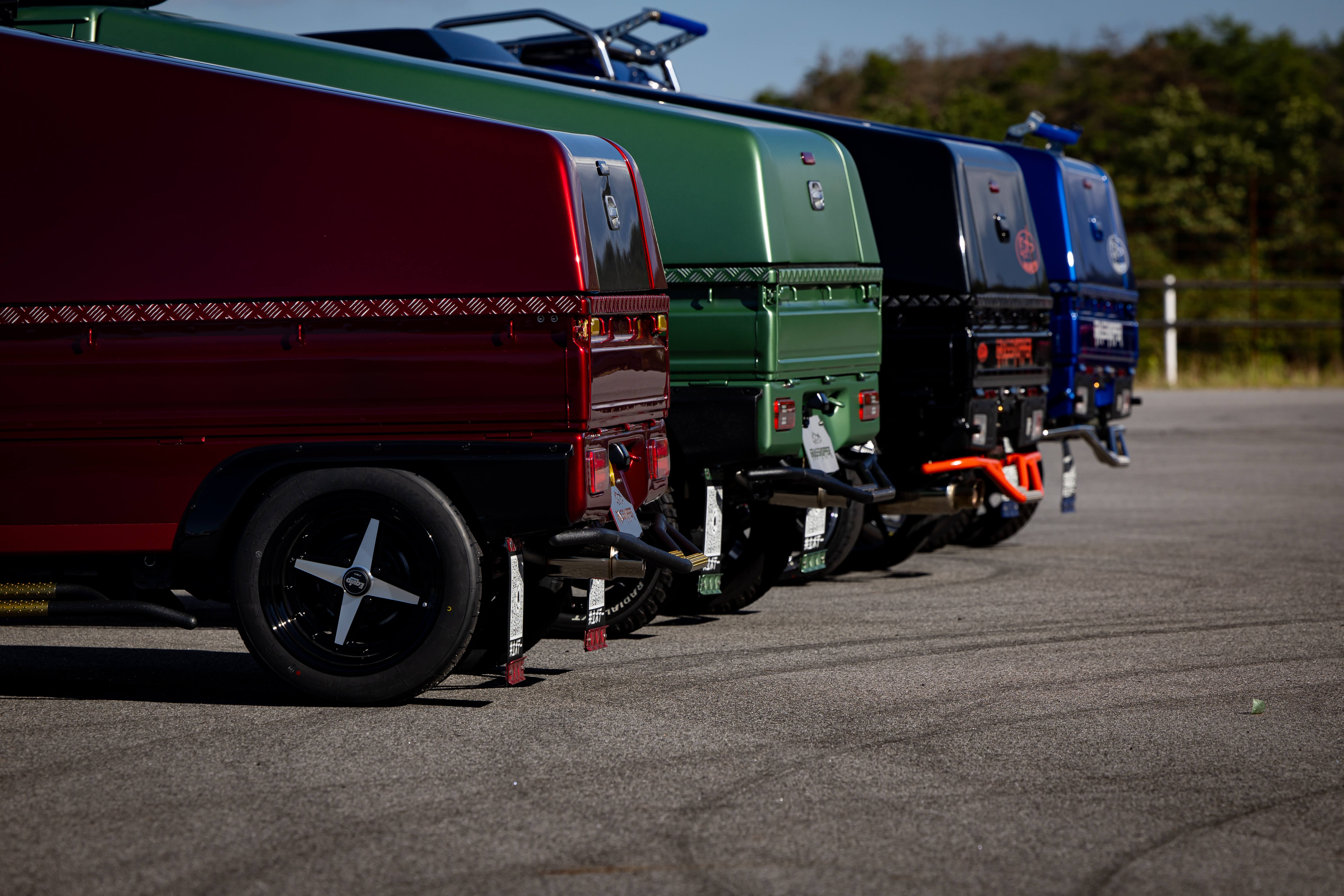 A colorful row of kei trucks parked; explore how much a kei truck costs and its benefits.