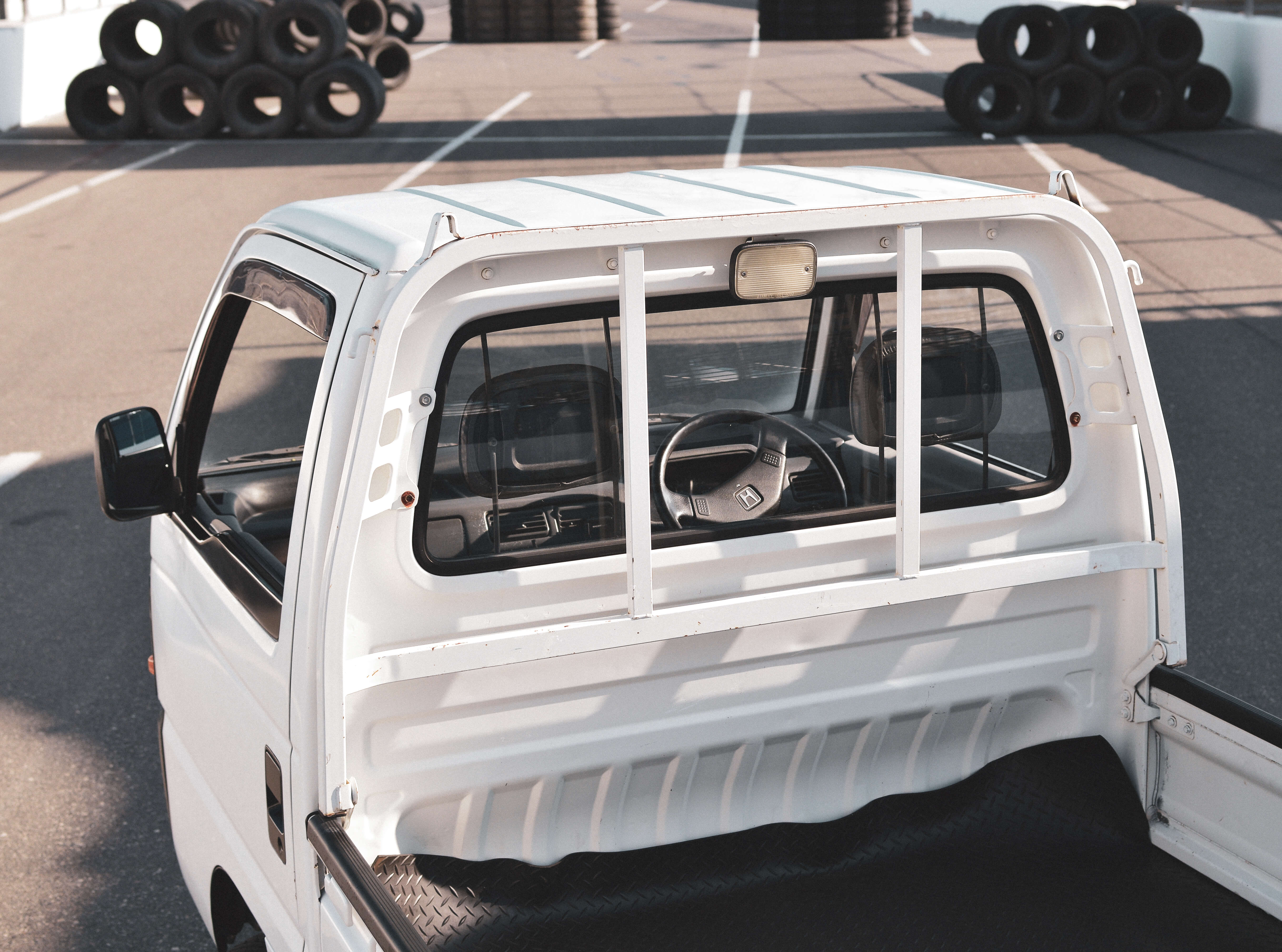 Japanese kei truck parked on a farm, showcasing its compact size and utility for rural transportation.