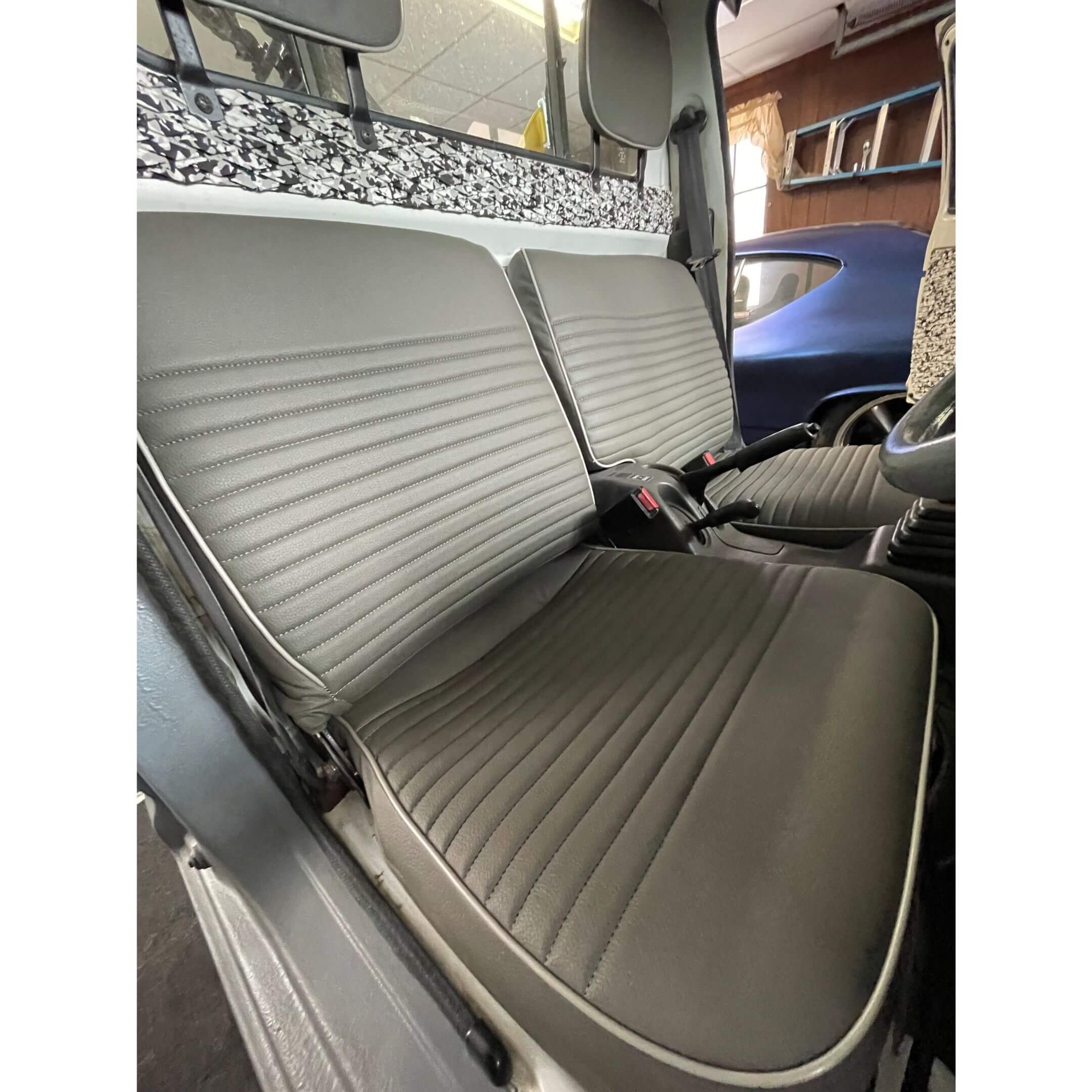 Custom fit bench seat cover installed on 1995 Suzuki Carry DD51T Kei Truck, gray and black stitched upholstery with piping for upgraded interior protection and comfort.
